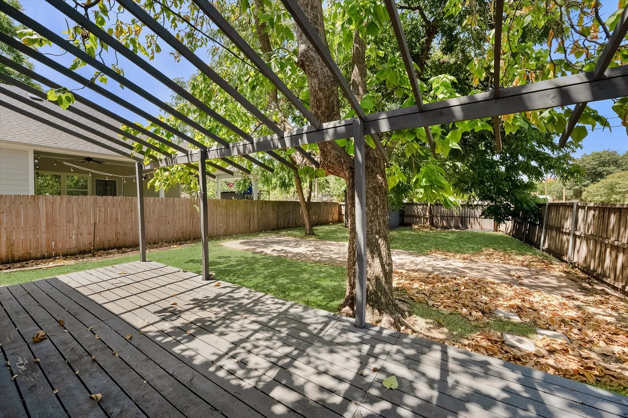 Backyard has deck and fence.