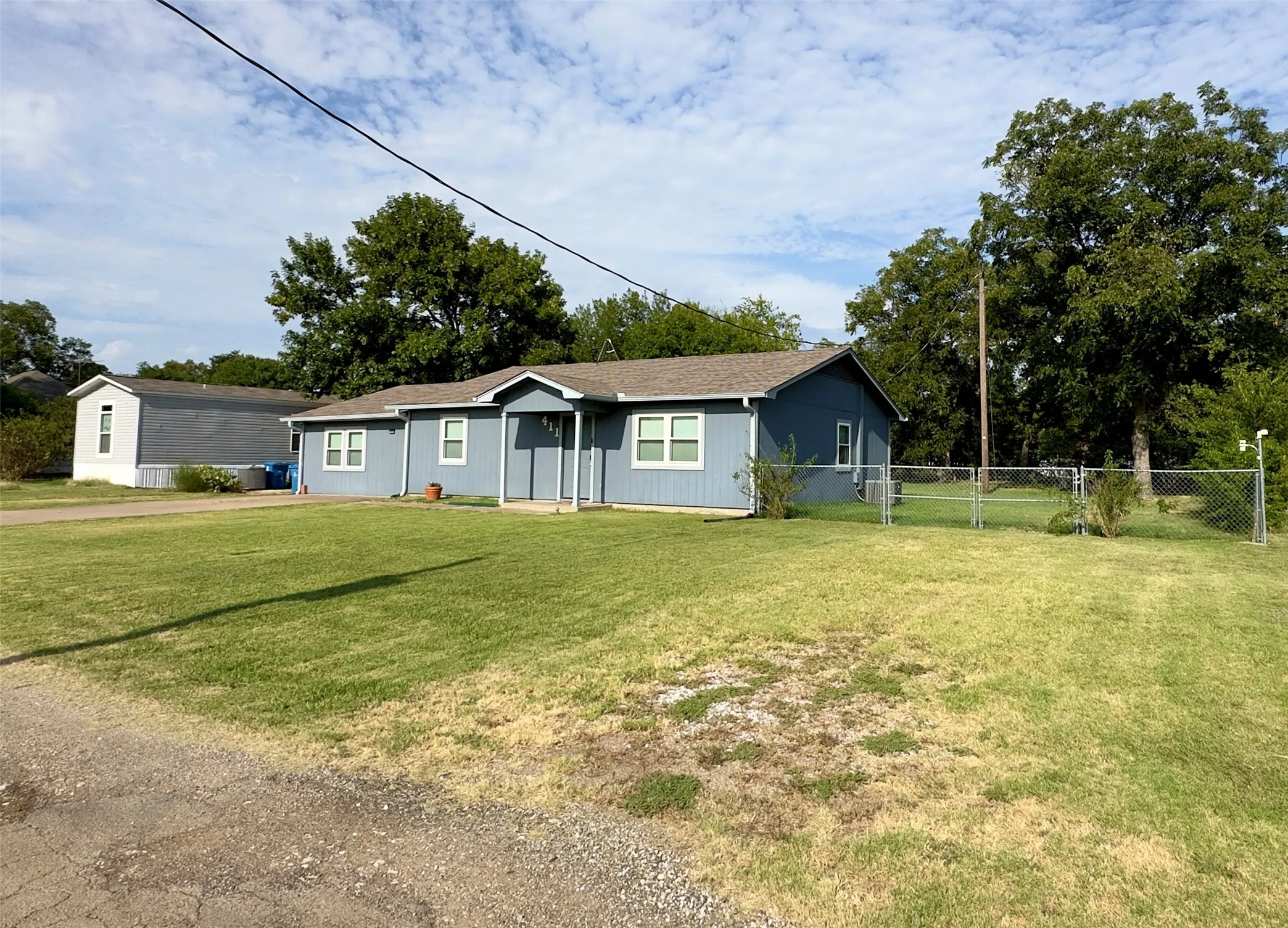 Single-story residence featuring a blue siding exterior, a gabled roof, and white window frames