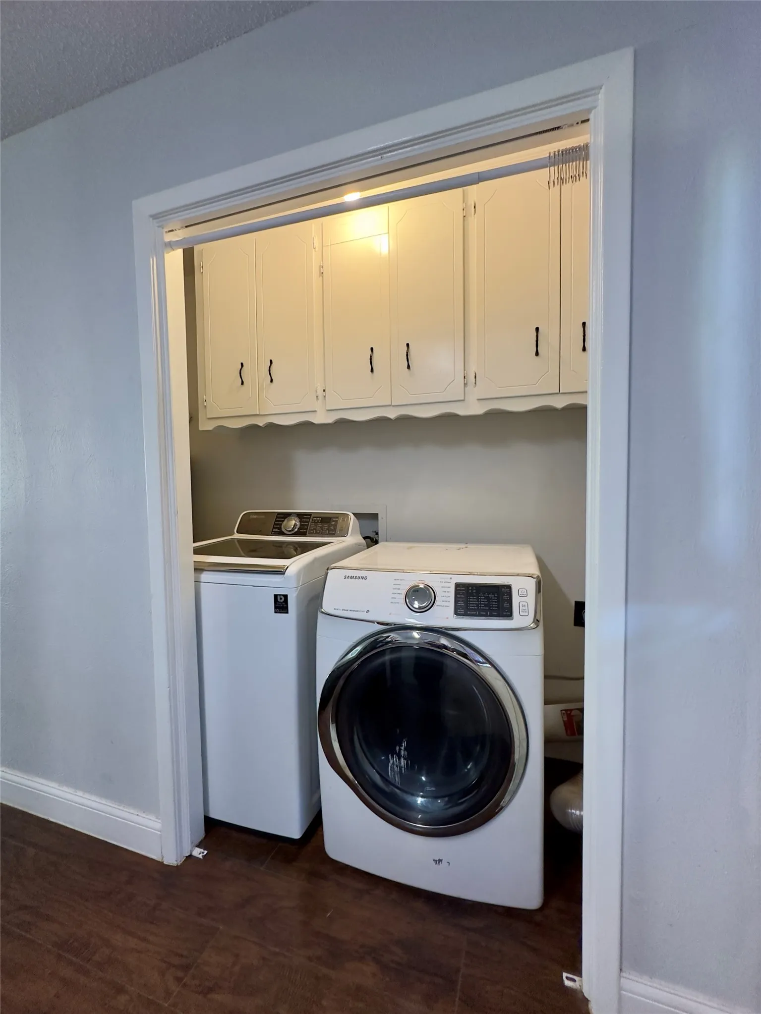 Built-in overhead white cabinetry, wood-finish flooring