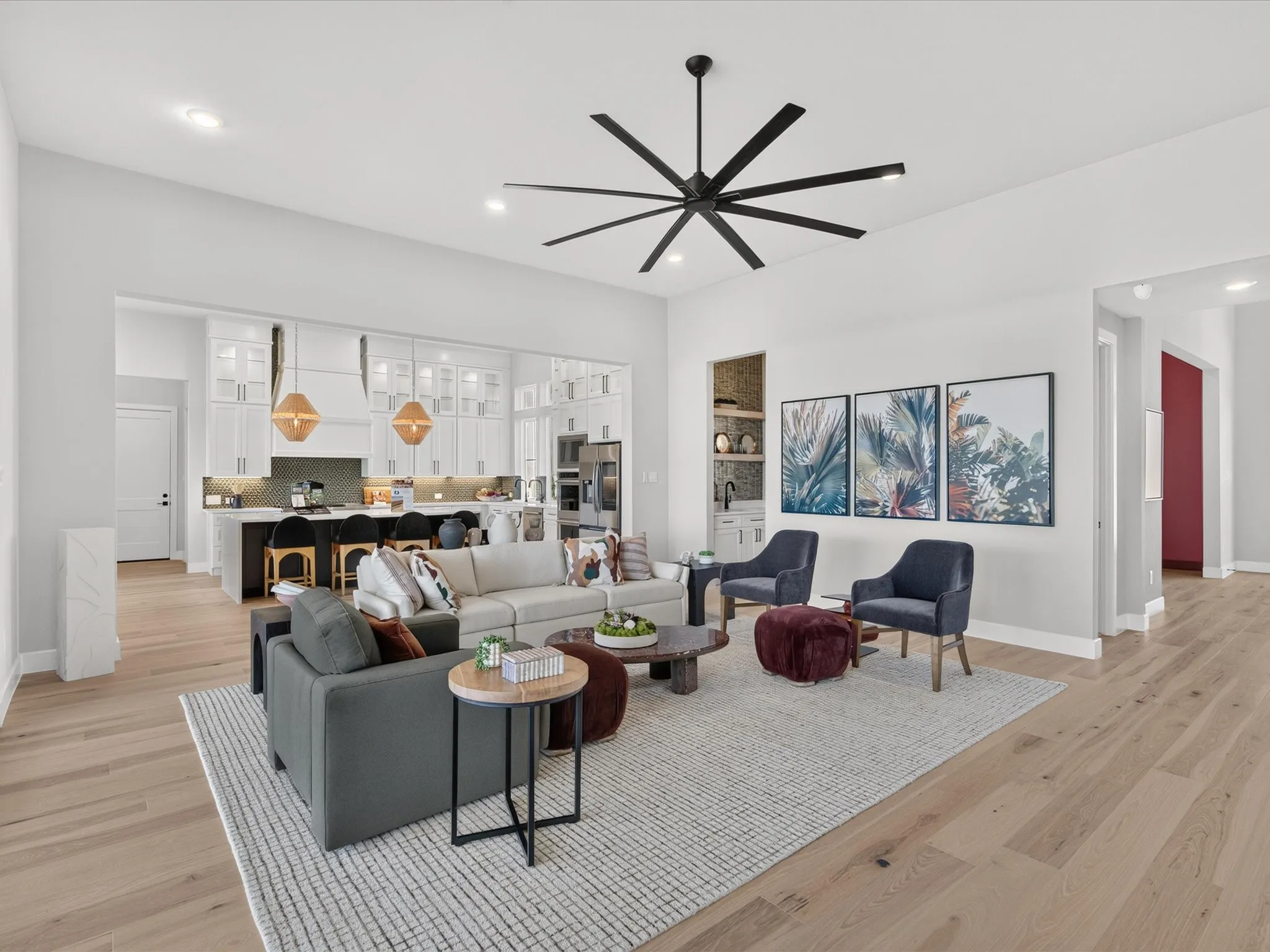 Open-concept living area featuring light wood-finish flooring, recessed lighting, and a large ceiling fan