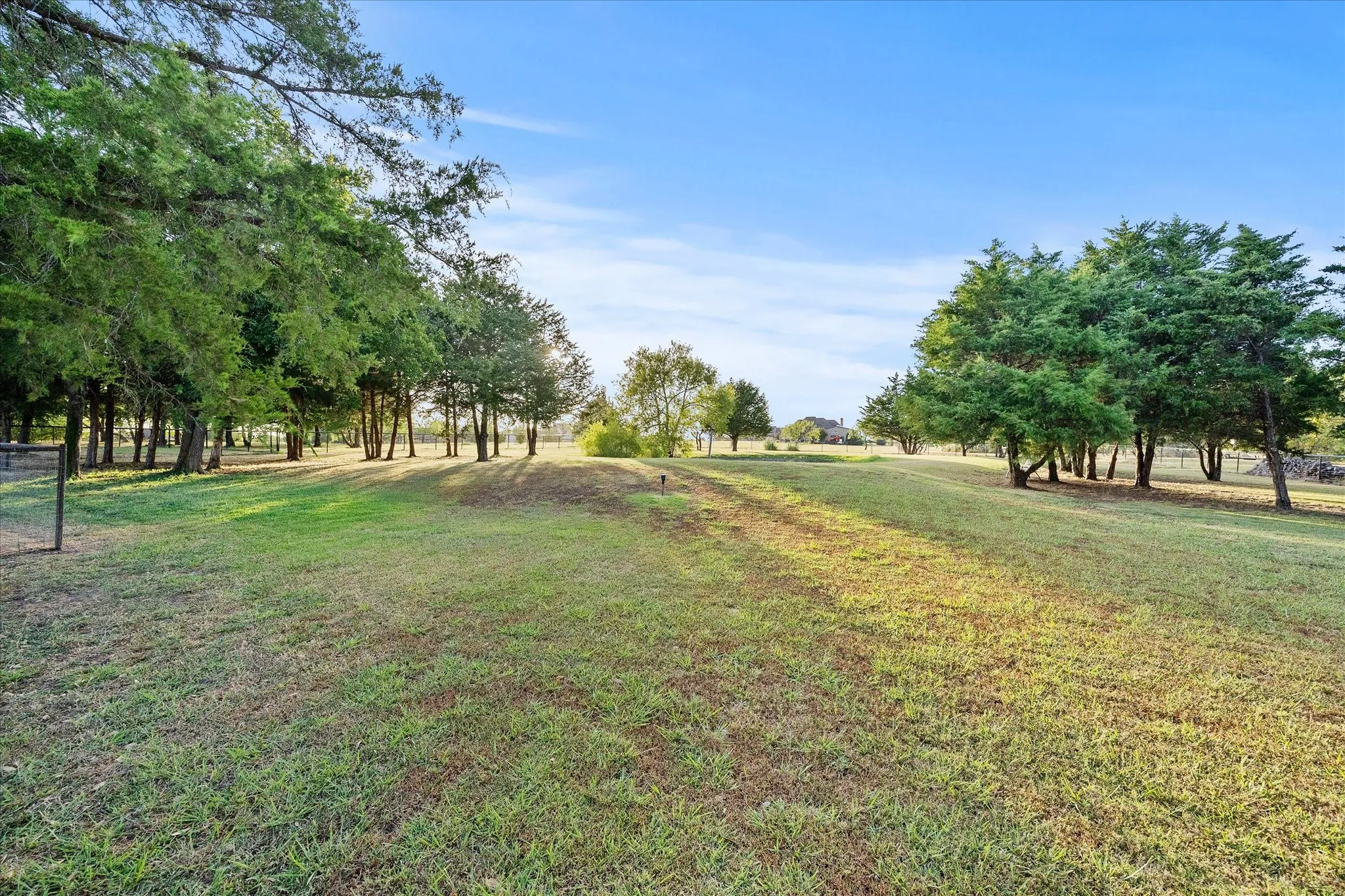 Expansive green space featuring mature trees and a manicured lawn