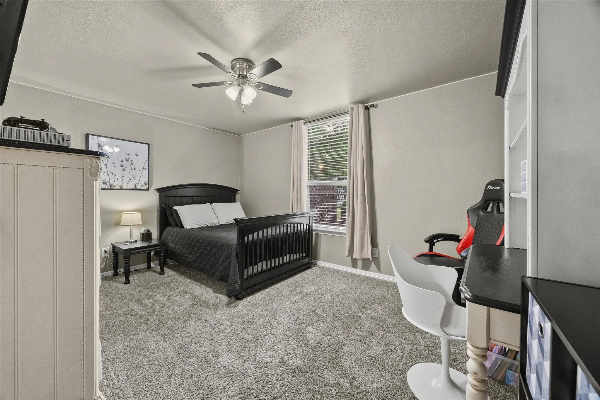 Carpeted room with a ceiling fan, window with blinds, and white trim