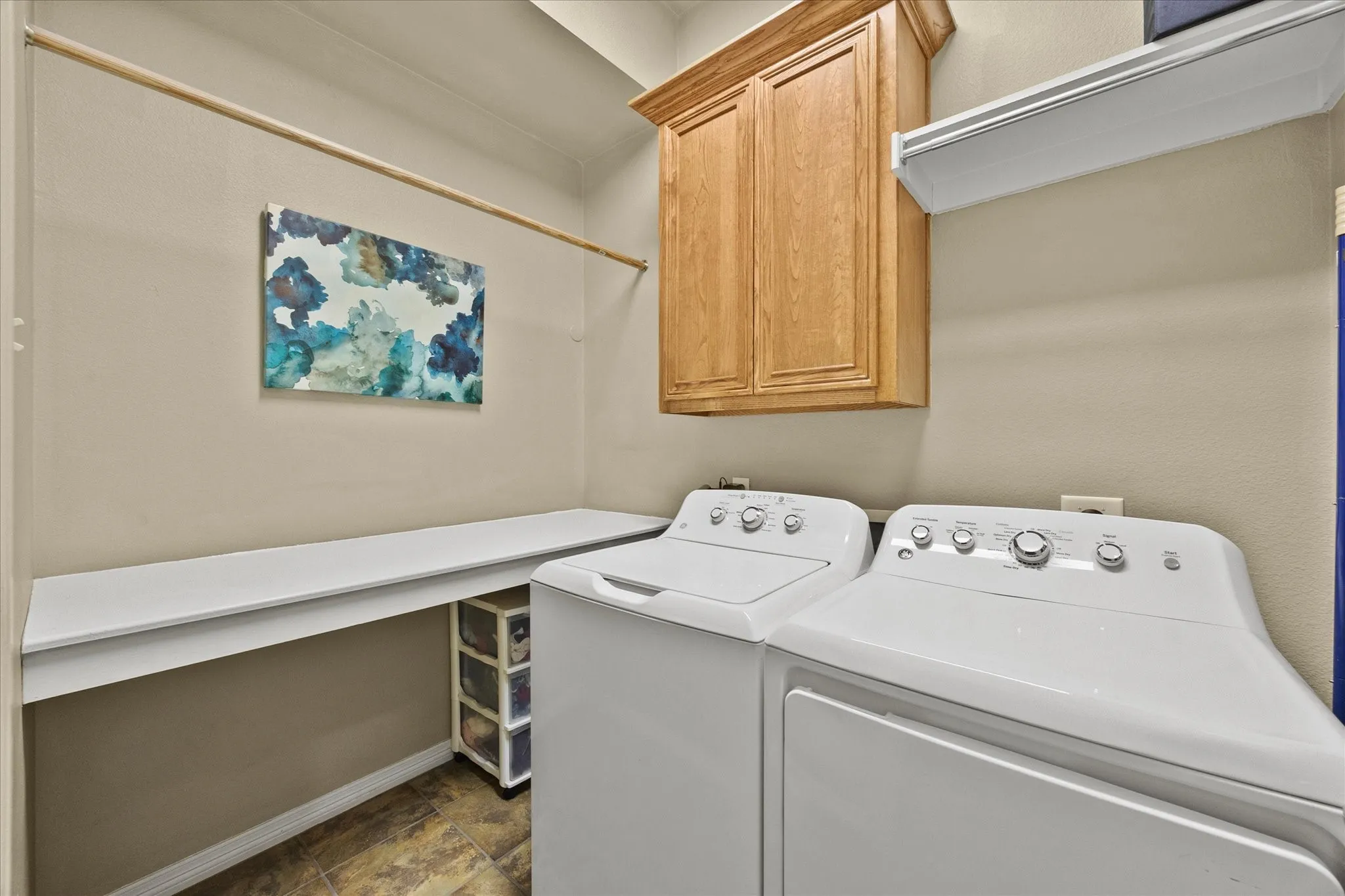 Built-in counter space, hanging rod, and overhead cabinetry provide organizational capabilities
