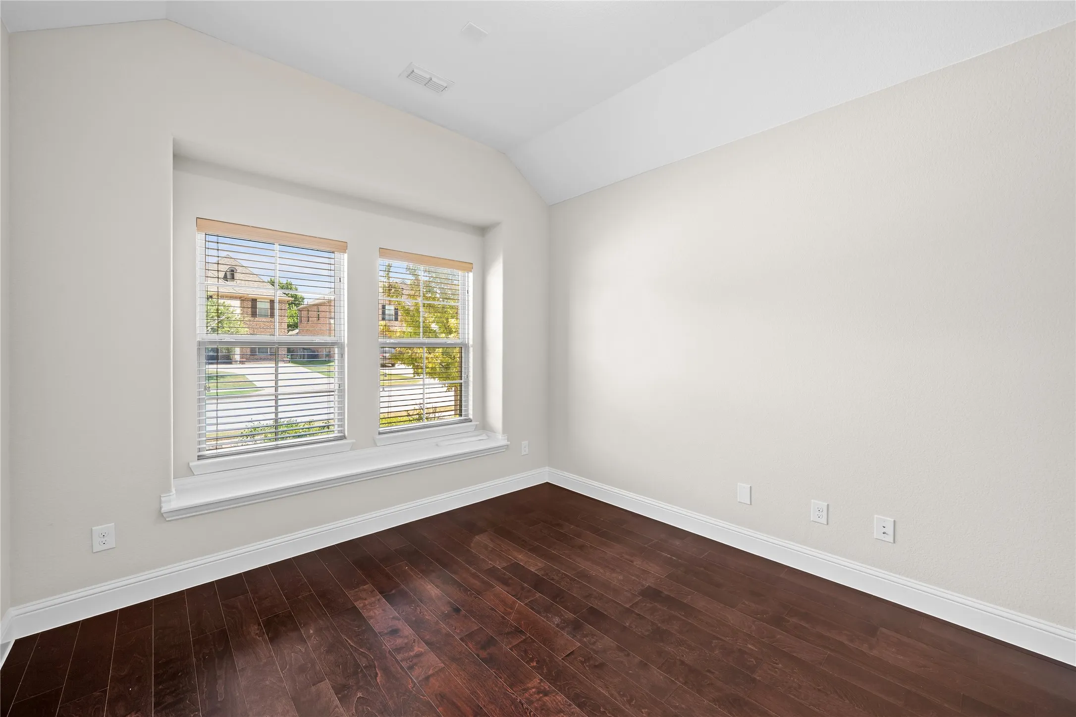 Recessed window with two double-hung windows, wood-finish flooring, and crisp white walls