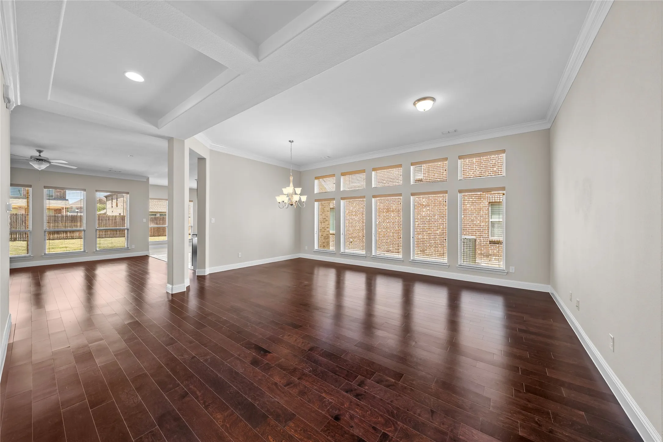 Spacious interior featuring wood-finish flooring, abundant natural light, crown molding, a coffered ceiling, and recessed lighting