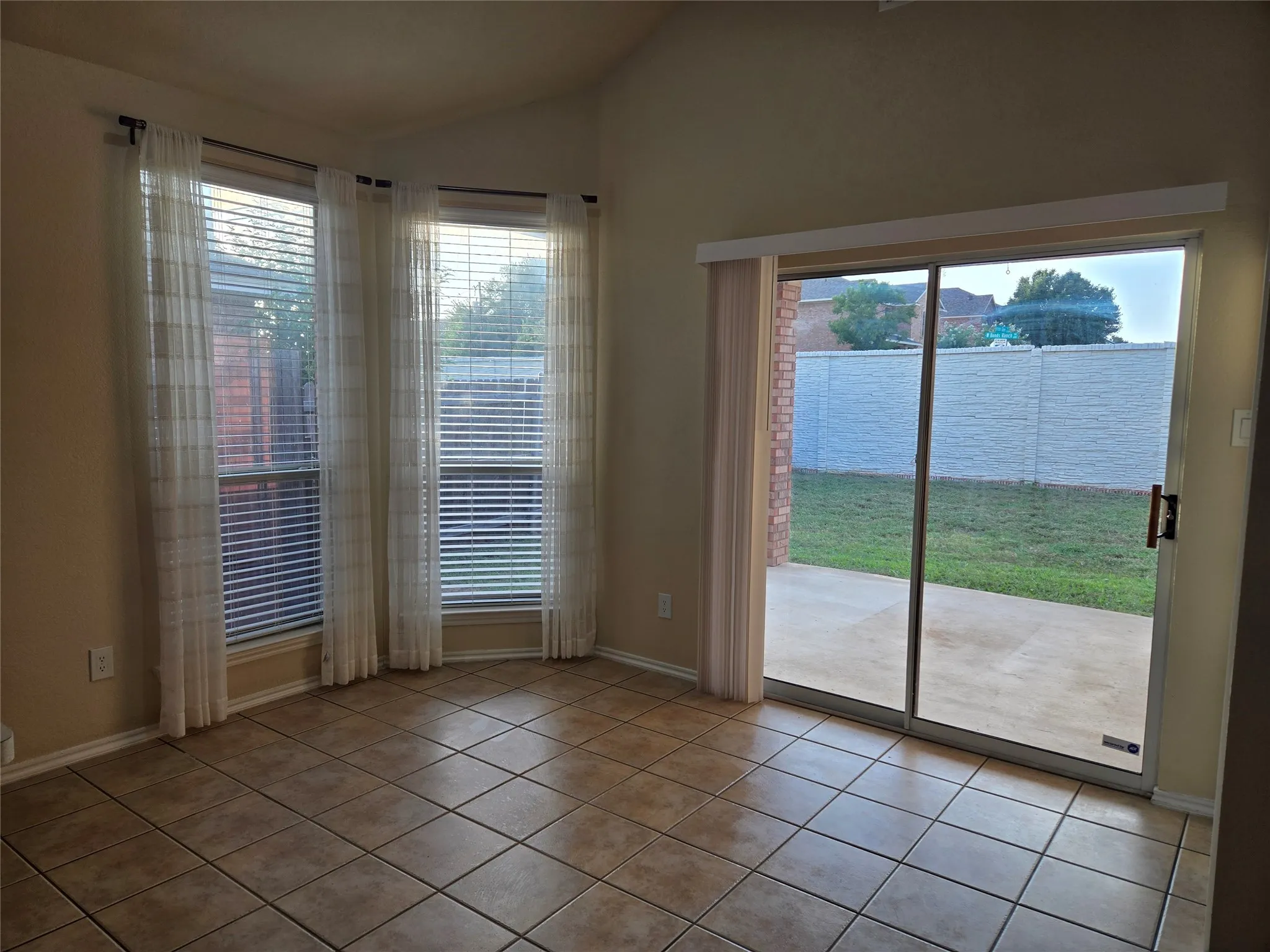 Dining room with light tile patterned flooring and vaulted ceiling