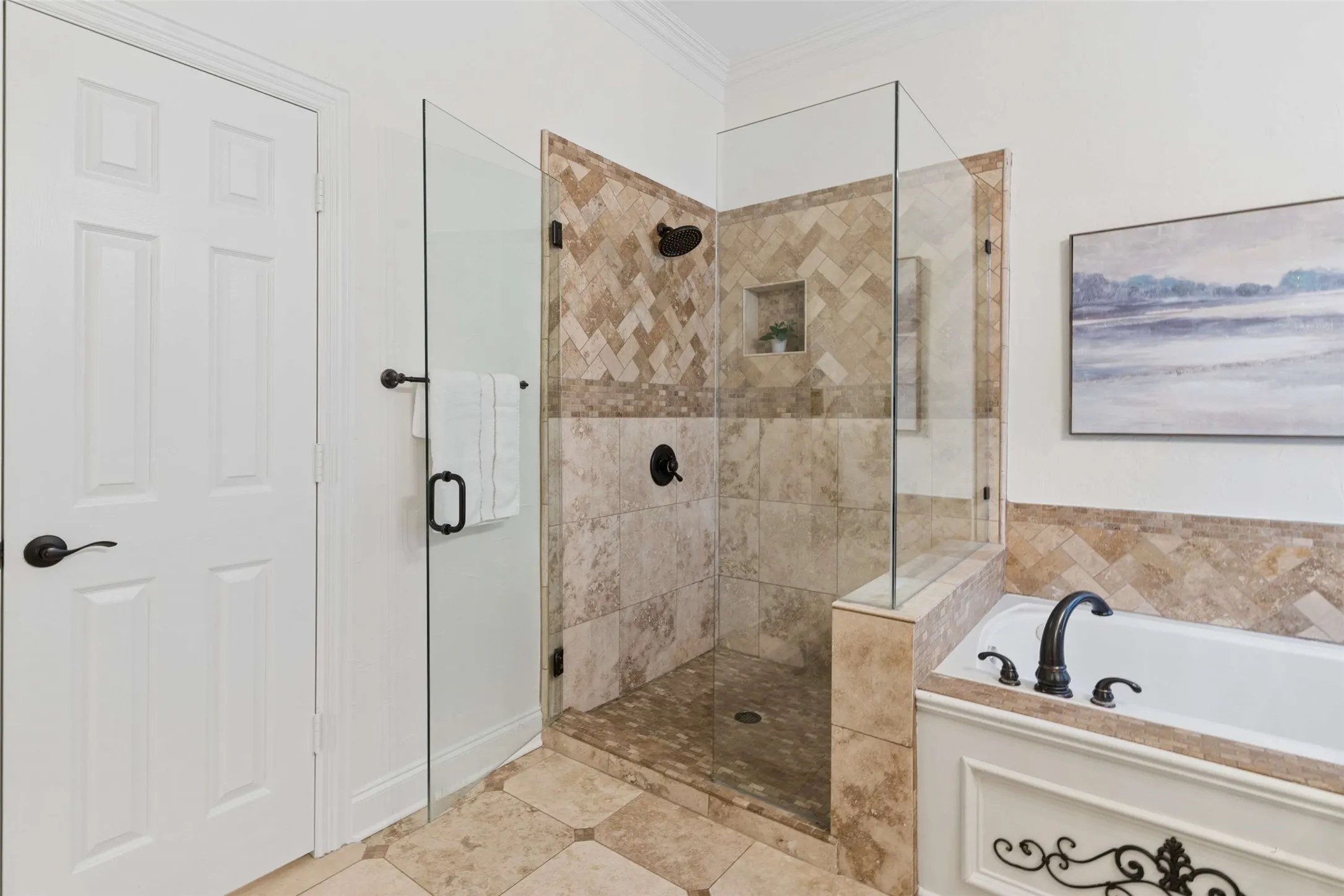Walk-in shower with clear glass enclosure and tile surround