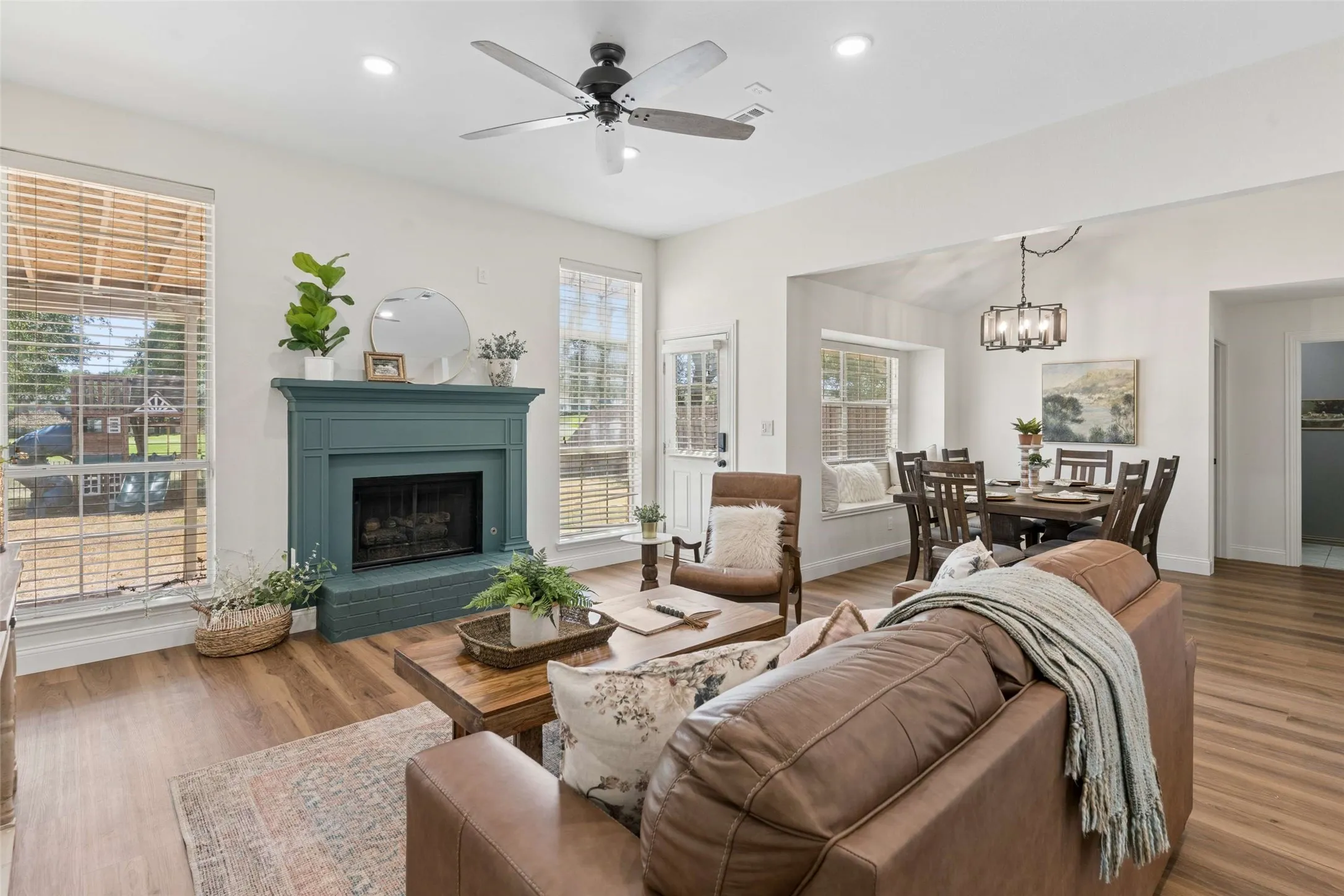 Spacious living area featuring wood-finish flooring, a decorative fireplace, and recessed lighting