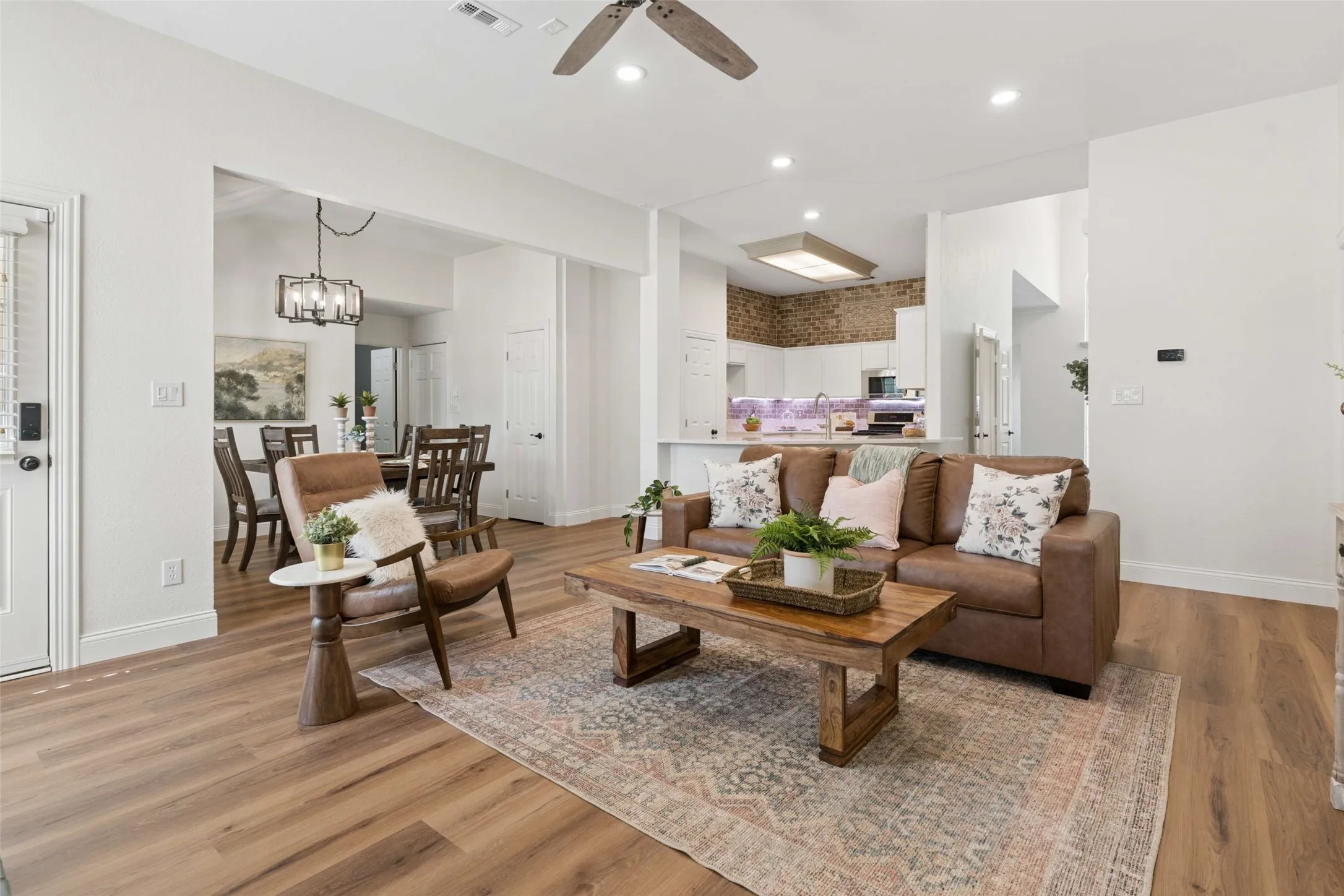 Open-concept living area with wood-finish flooring, recessed lighting, and a ceiling fan