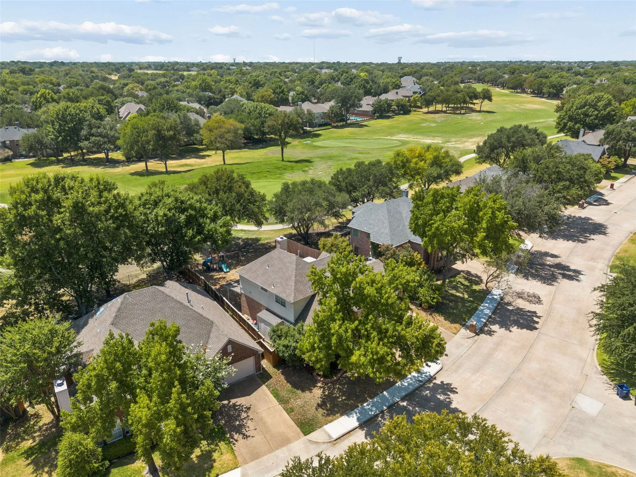 Property situated on a curved street with mature trees and a golf course beyond the rear boundary