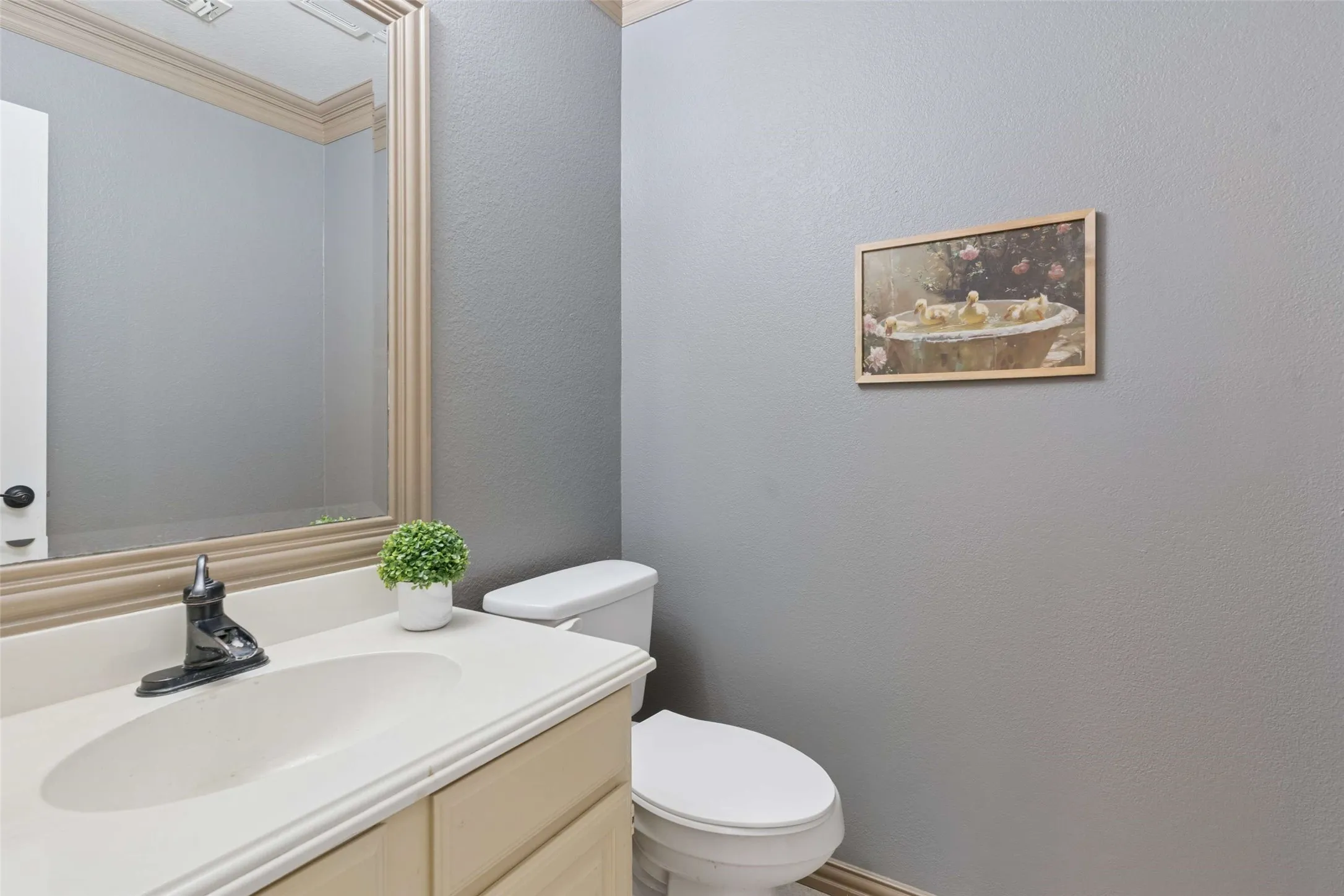 White vanity with an integrated sink, framed mirror, and chrome faucet