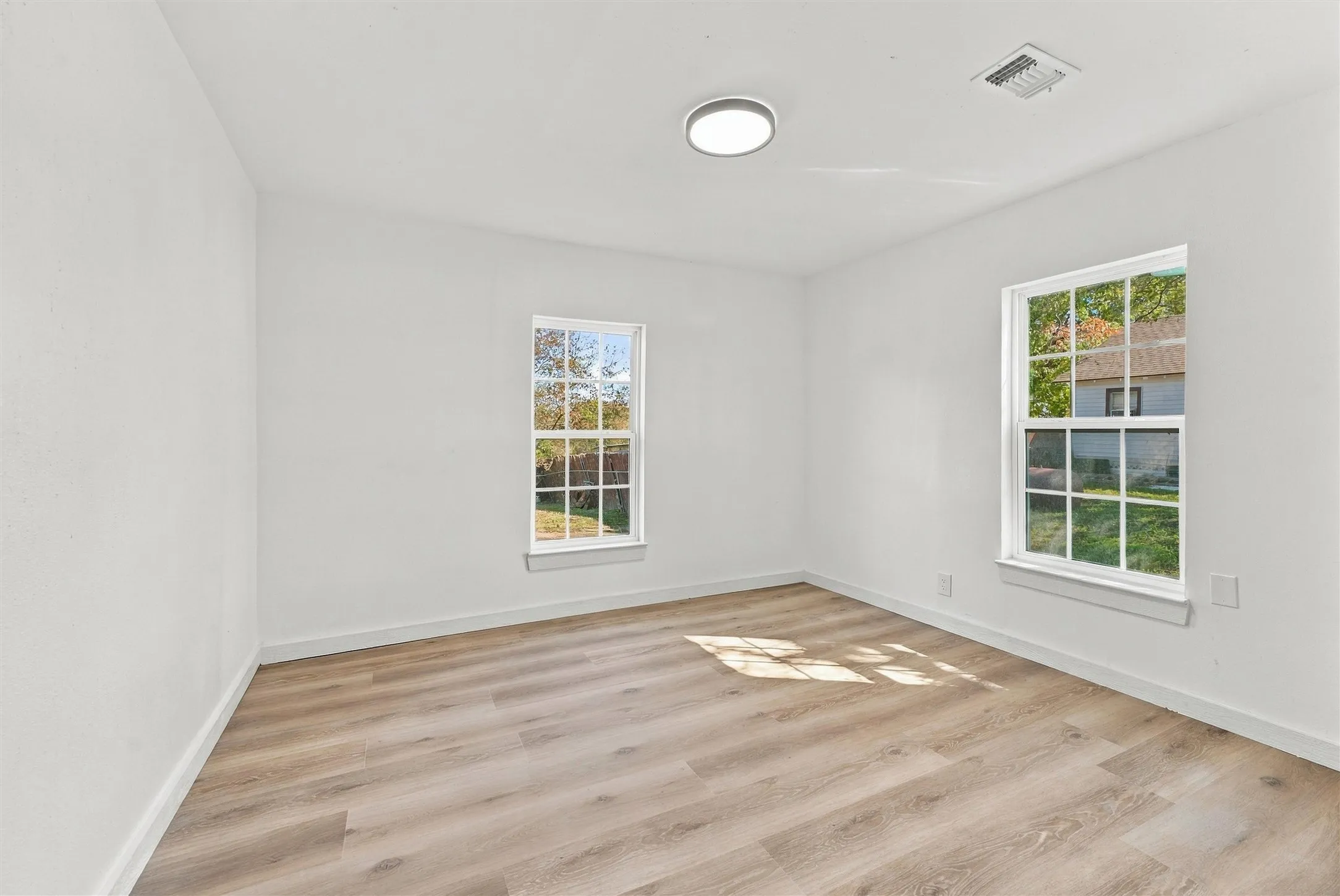 Bedroom with new flooring, sheetrock, natural lighting, and fresh feel.