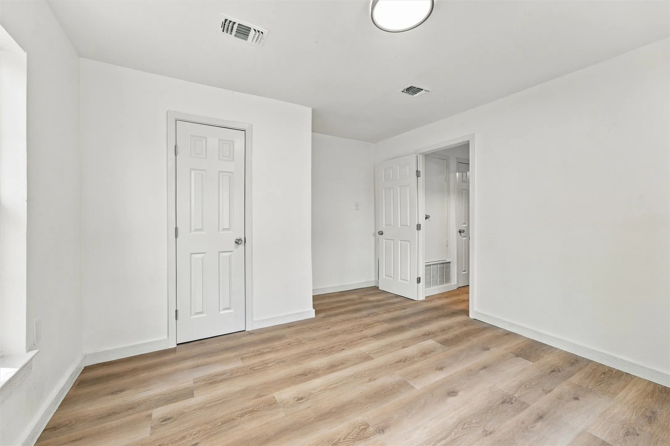 Spacious remodeled bedroom with attached closet.