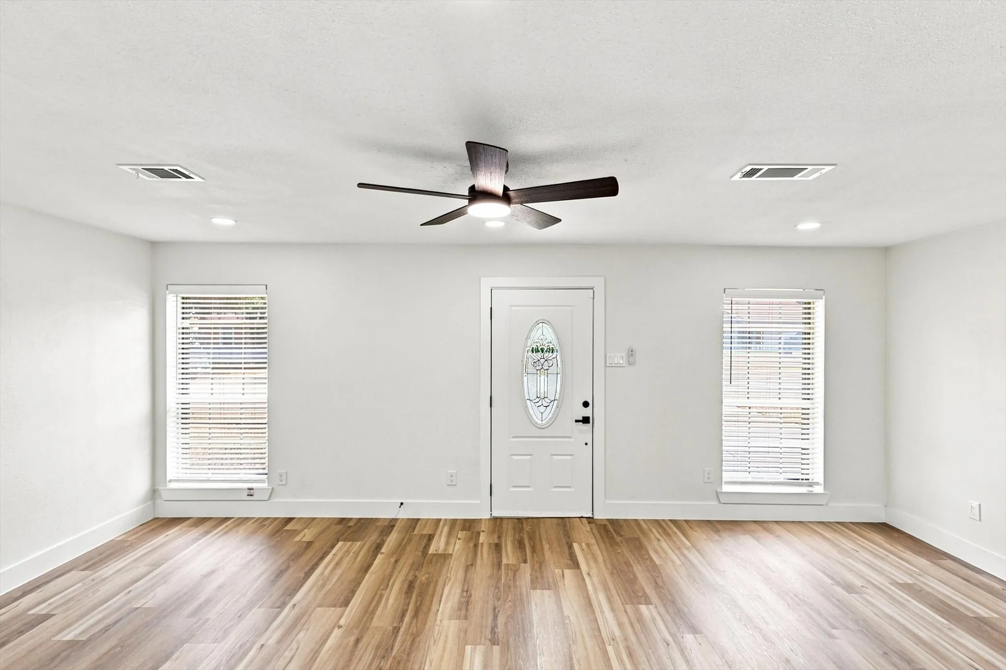 Wood-finish flooring, recessed lighting, and a ceiling fan with integrated illumination
