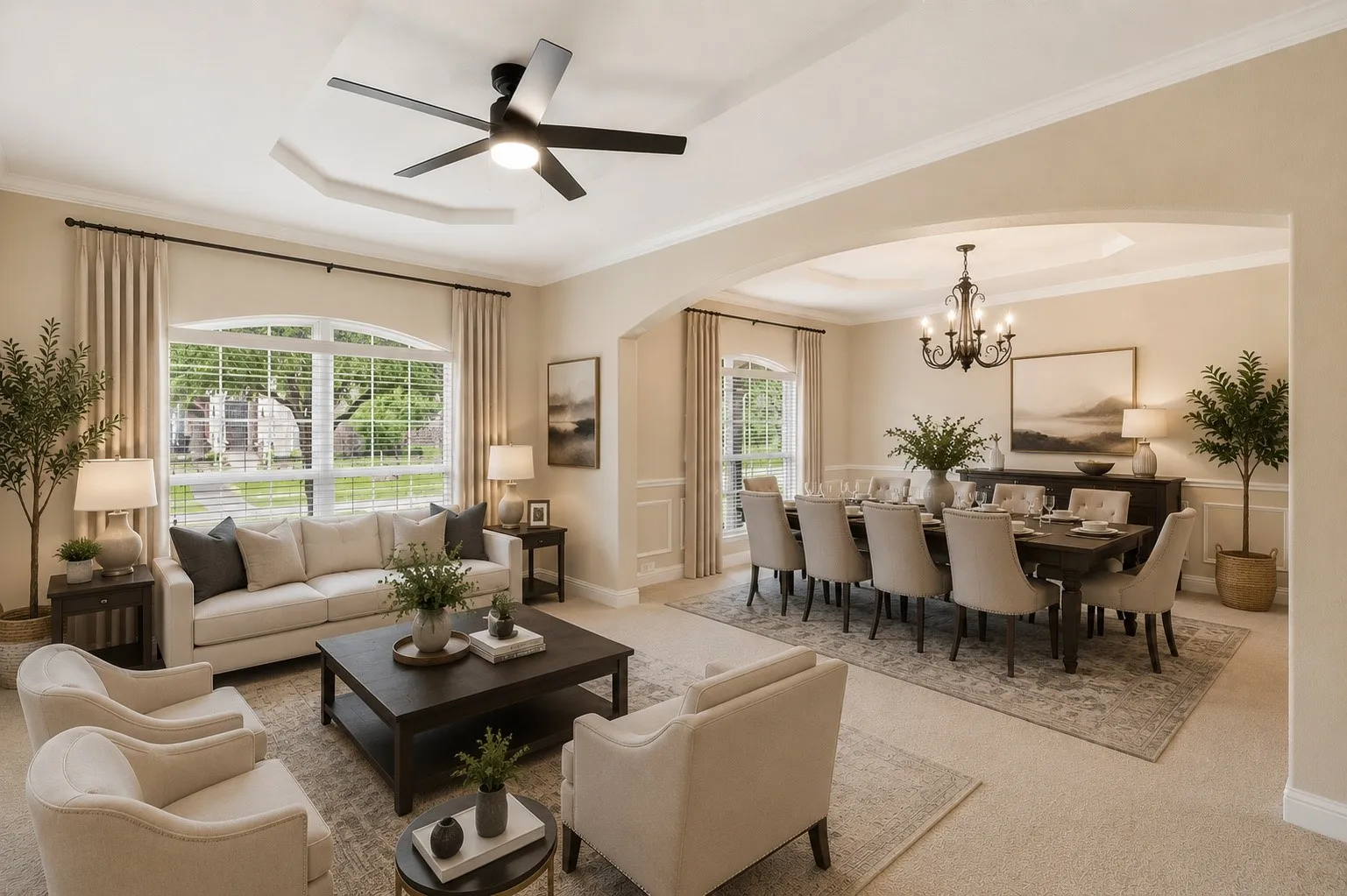 Virtually Staged Spacious living area featuring an arched window, ceiling fan, and tray ceiling