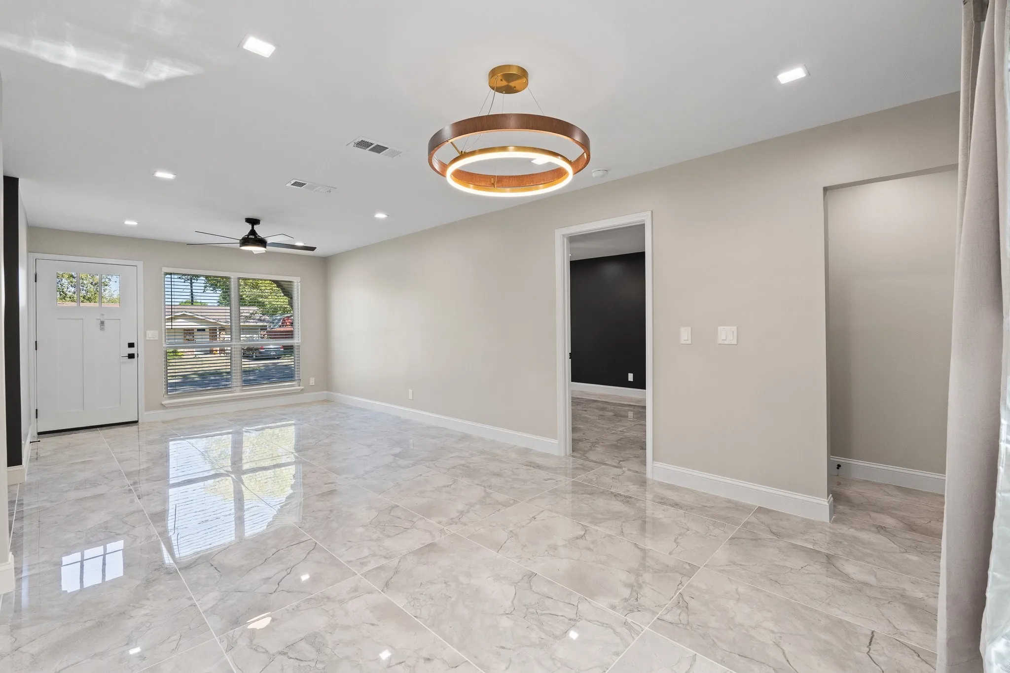 A view of the open concept livingroom and dining. All new flooring. New lighting. Fresh paint.