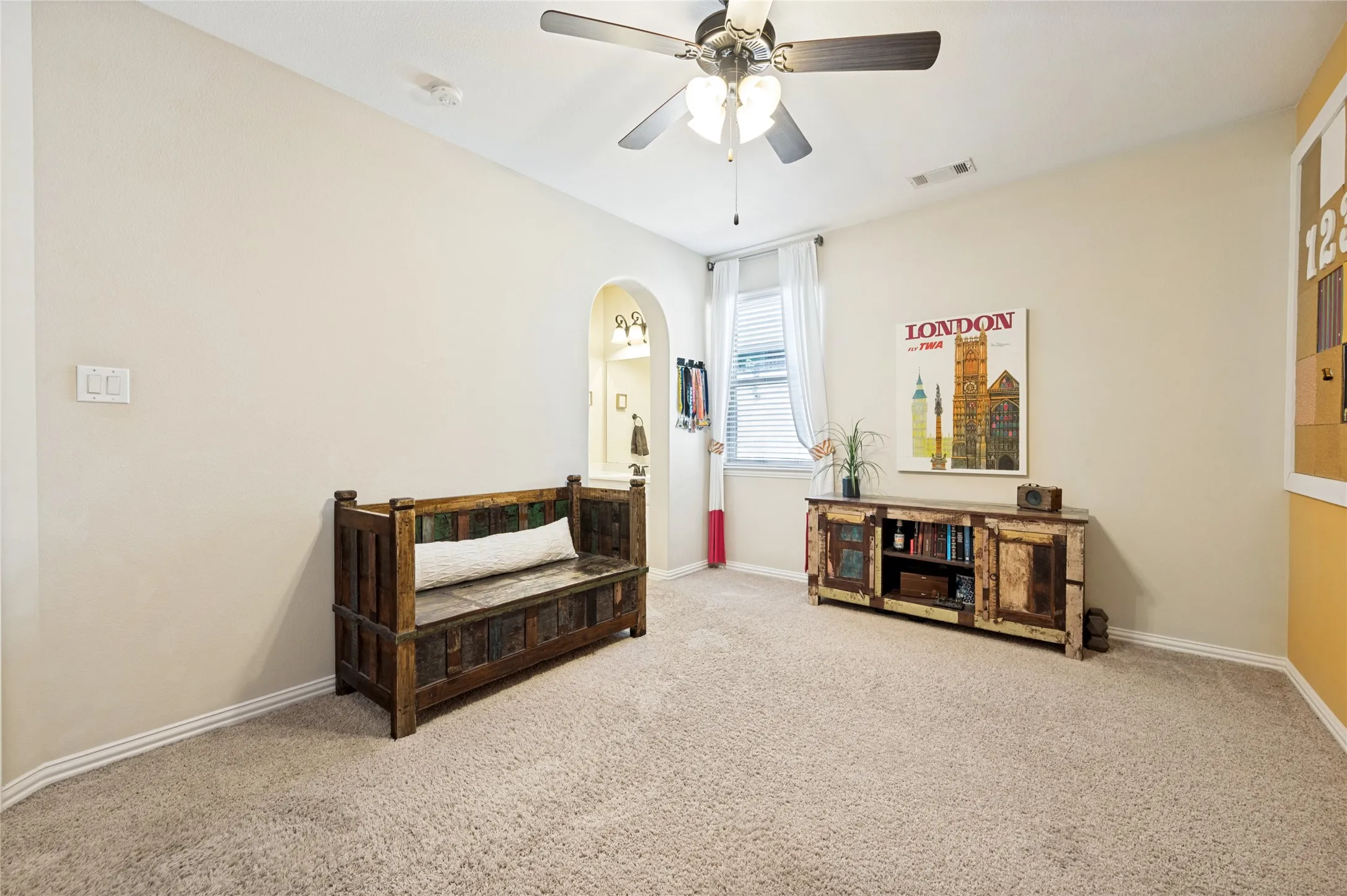 This spacious secondary bedroom is located on the upper level and includes a Jack and Jill bathroom, a ceiling fan, and a walk-in closet.