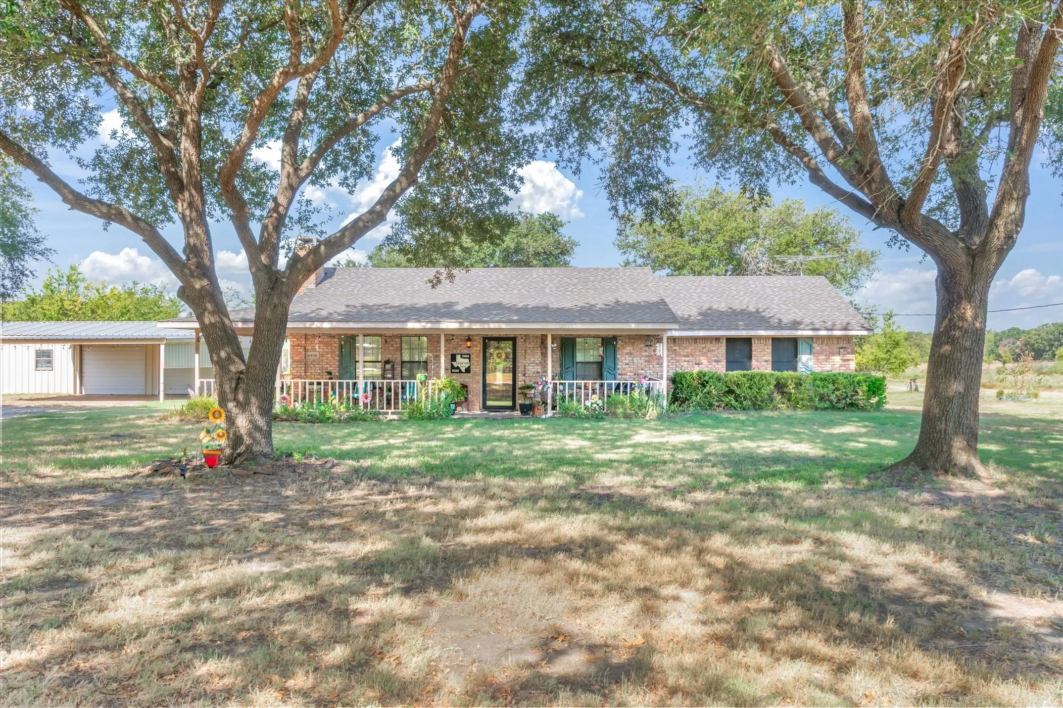 Brick exterior with a covered front porch featuring a white railing