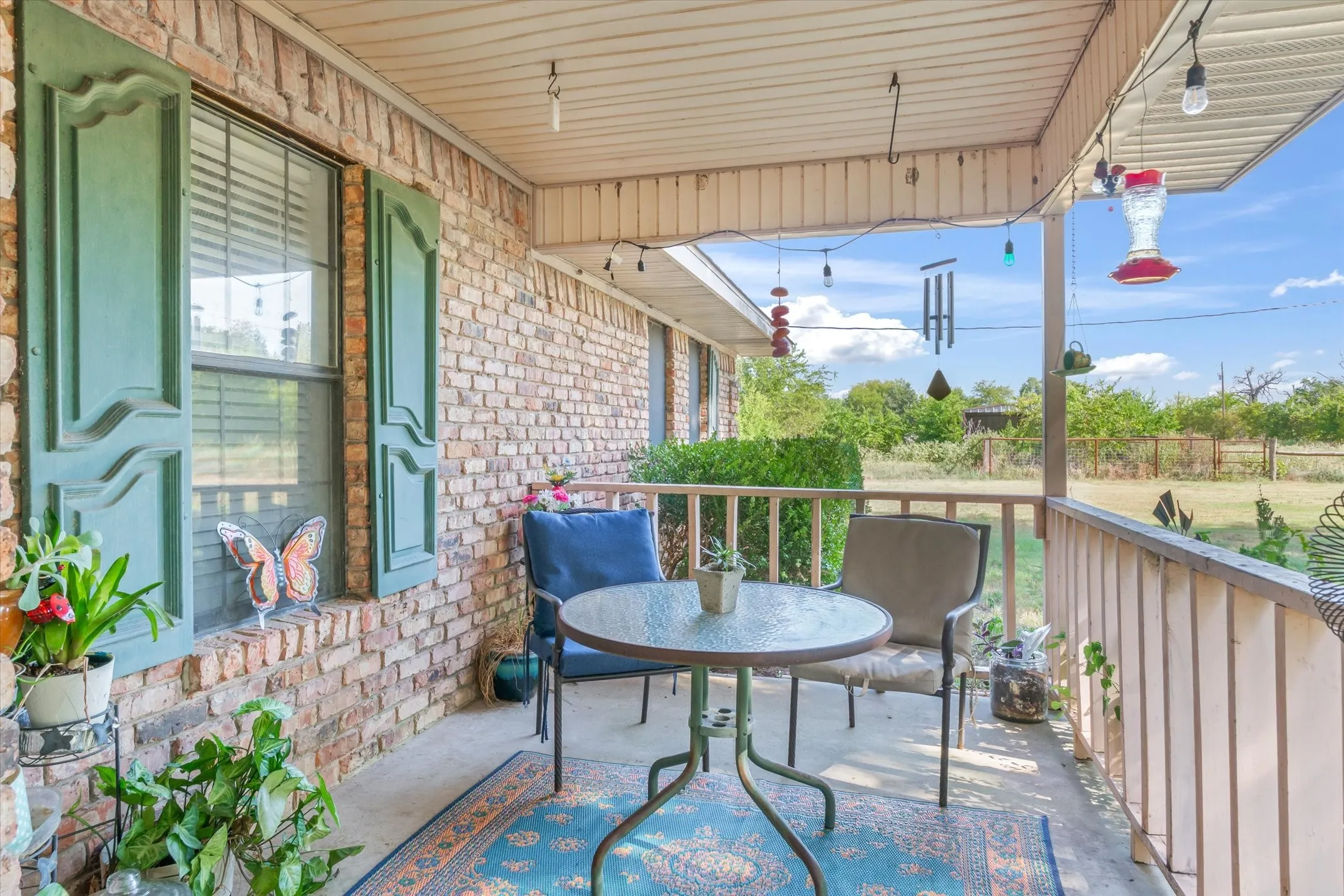 Brick exterior with decorative shutters, covered porch, and spindle railings