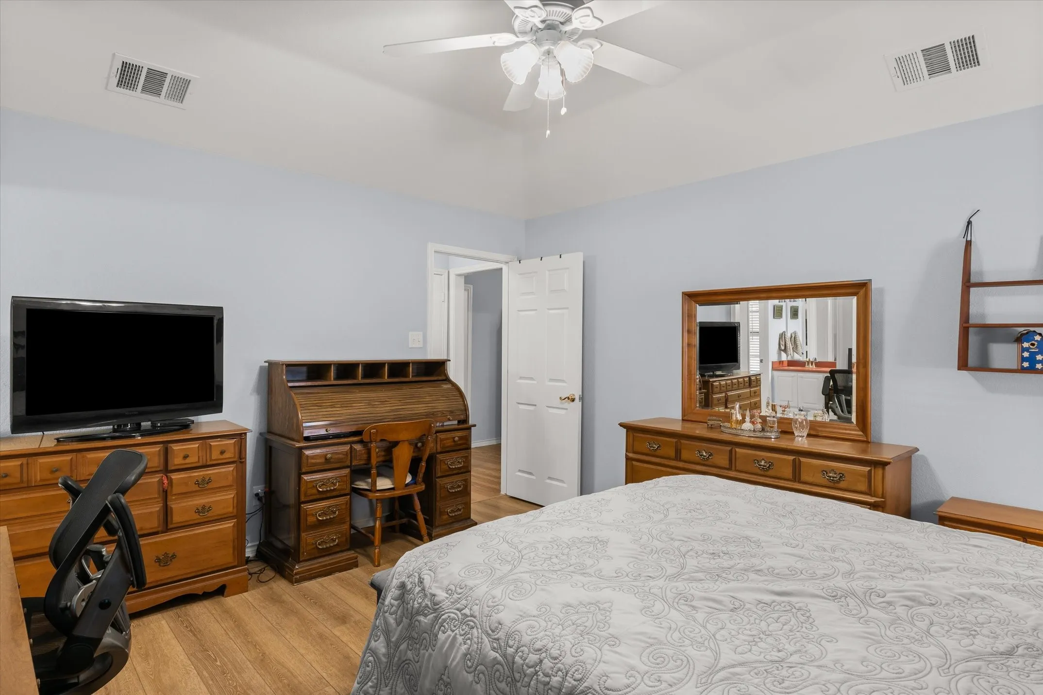 Vaulted ceiling with a ceiling fan, wood-finish flooring, and white interior doors