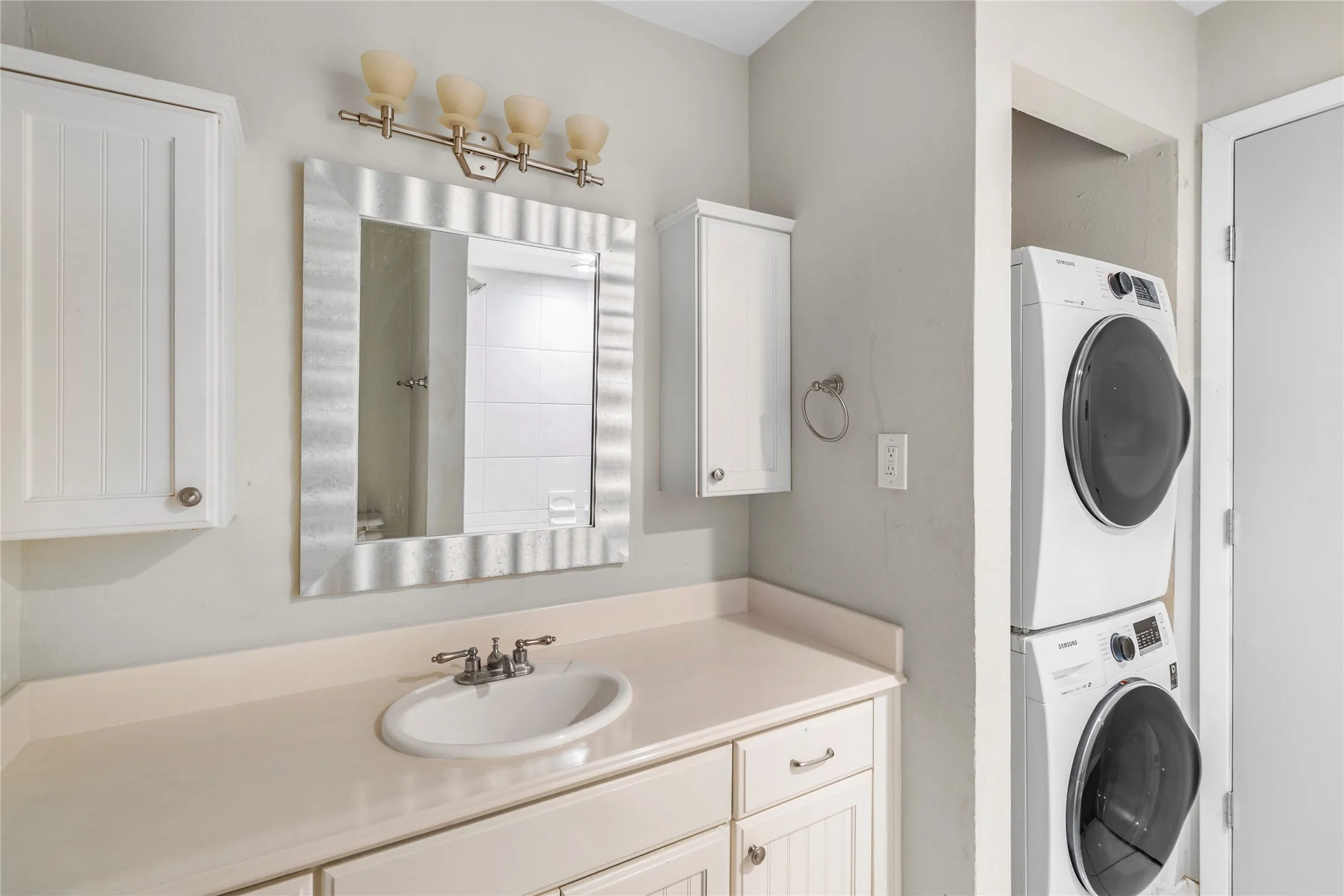Bathroom featuring vanity and stacked washer and clothes dryer