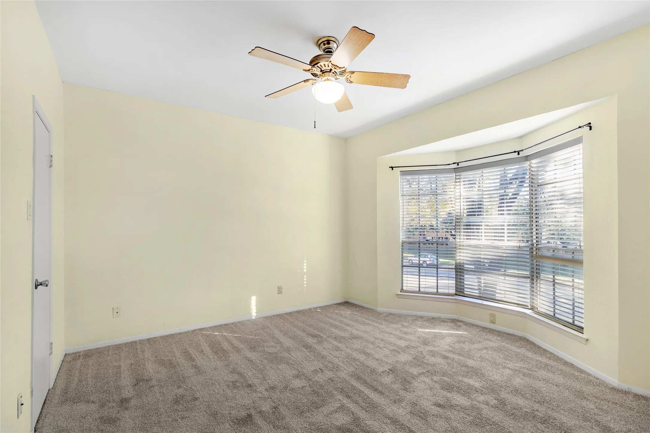 Carpeted room with baseboards and a ceiling fan