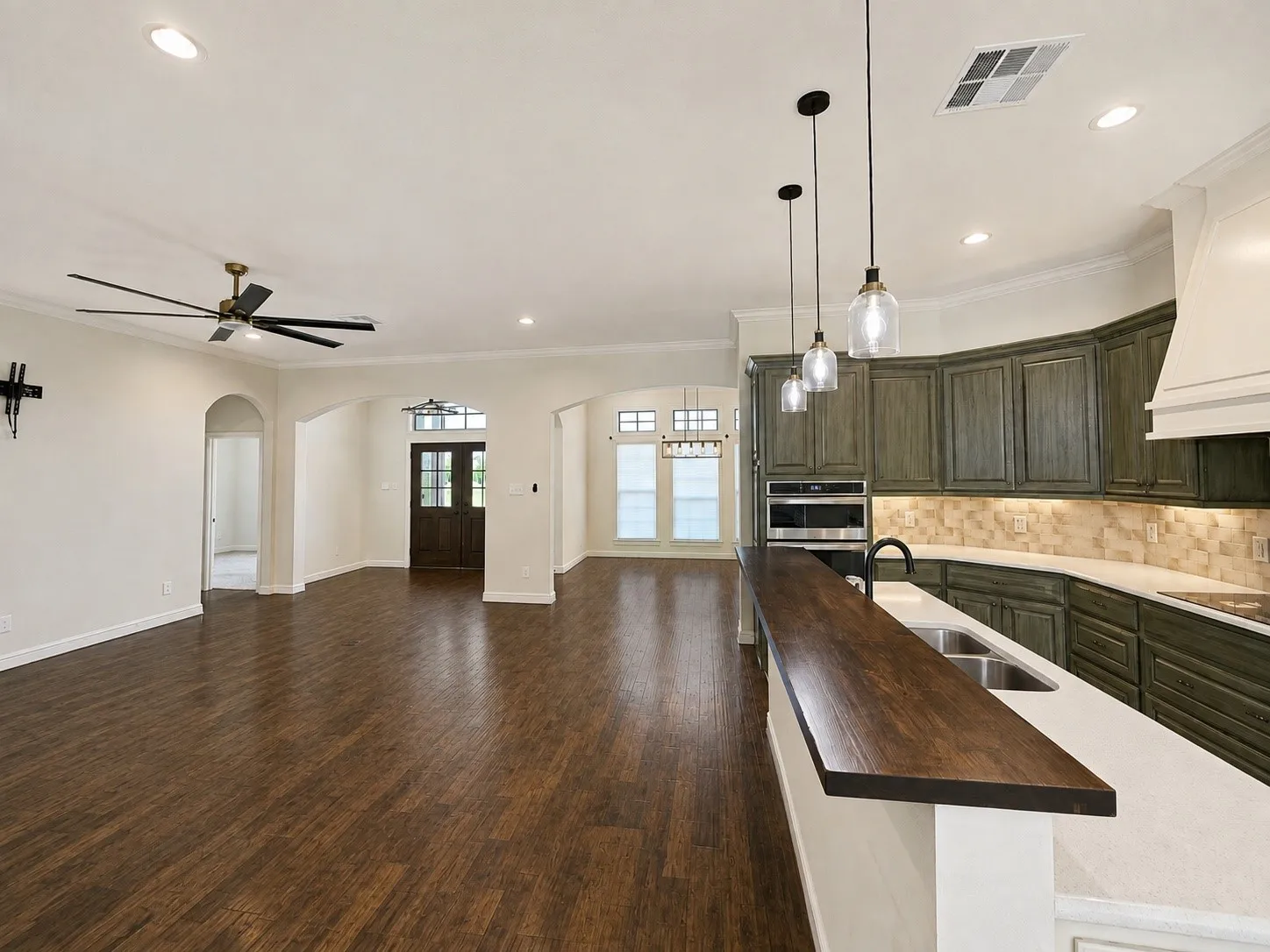 Wood-finish flooring, recessed lighting, and crown molding