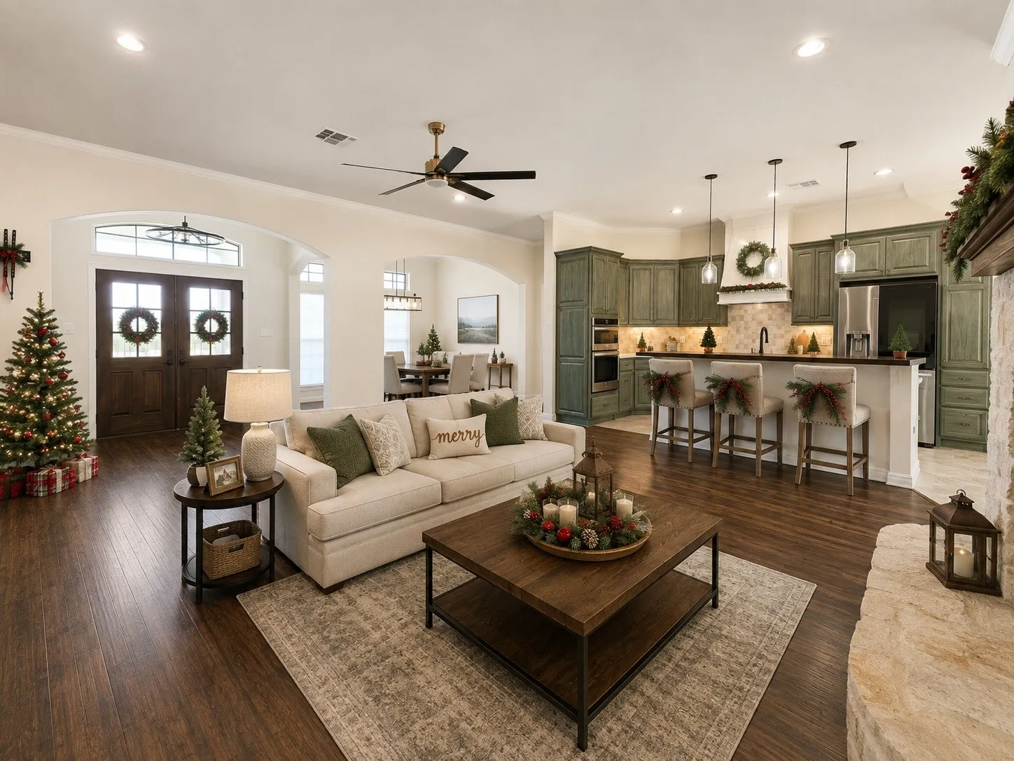 Open-concept living area with wood-finish flooring, a stone-clad fireplace, and a kitchen featuring a tile backsplash, island with pendant lighting, and built-in appliances