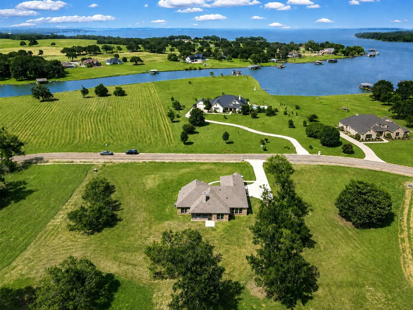 Expansive property featuring a large body of water, lush green landscapes, and multiple residential structures
