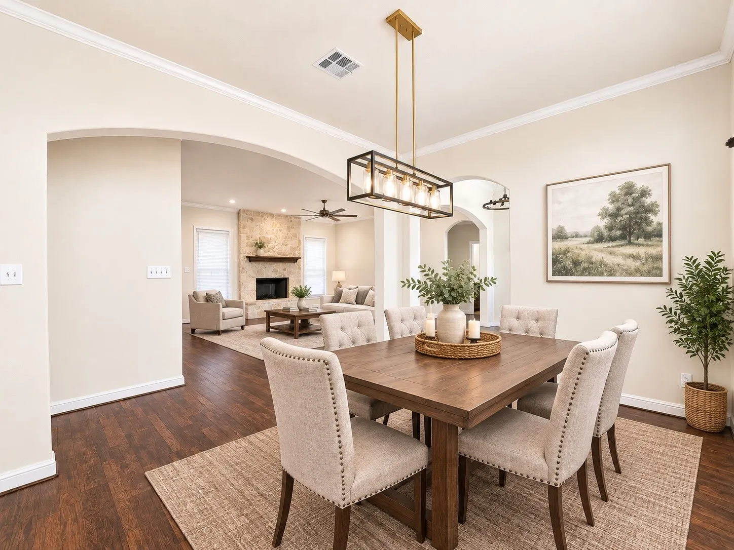 Wood-finish flooring, crown molding, arched entryways, and a modern linear chandelier
