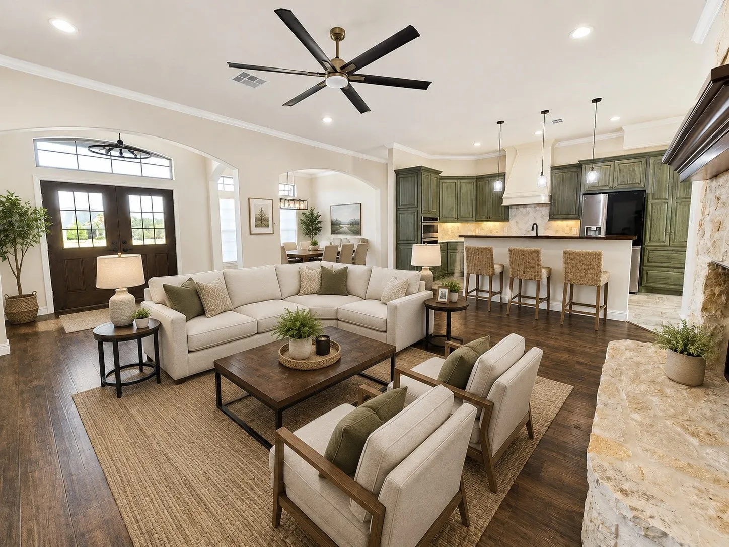Open-concept living space with wood-finish flooring, a stone-clad fireplace, and a ceiling fan