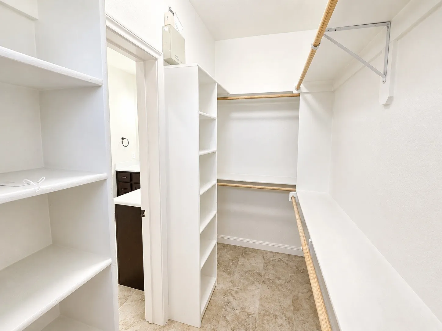 Walk-in closet featuring built-in shelving, hanging rods, and light-toned flooring