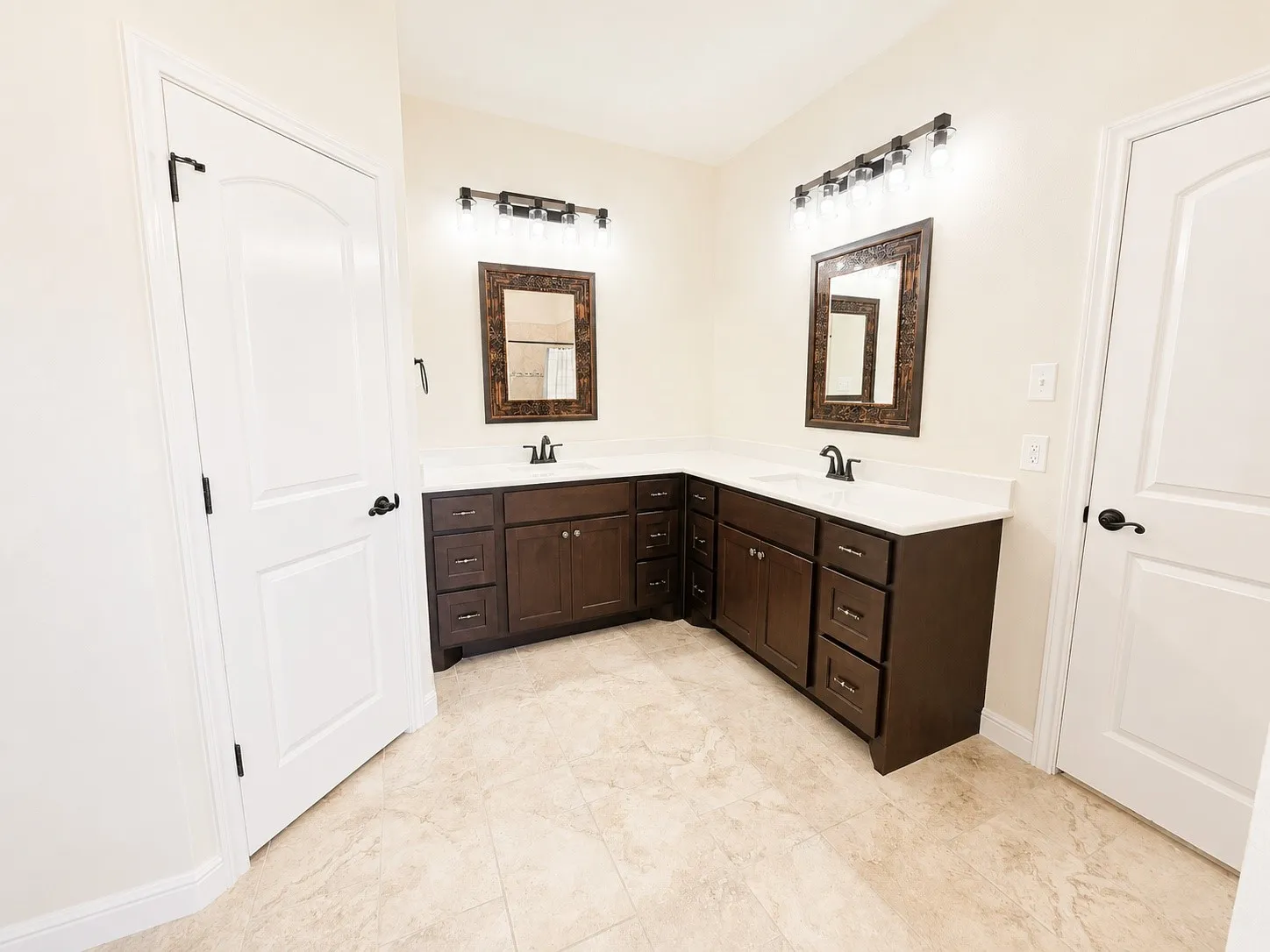 Dual vanity with dark wood-finish cabinetry, white countertops, and integrated sinks