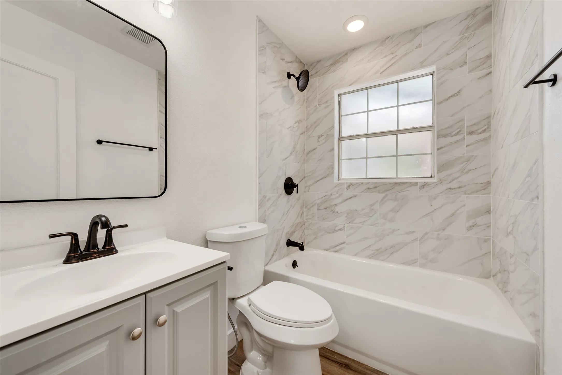 White tiled shower surround with matte black fixtures