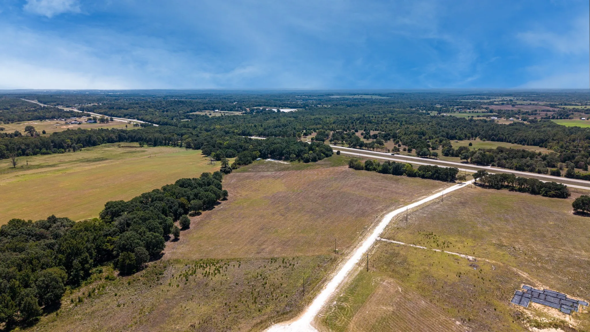 Expansive rural property featuring open fields and mature tree lines