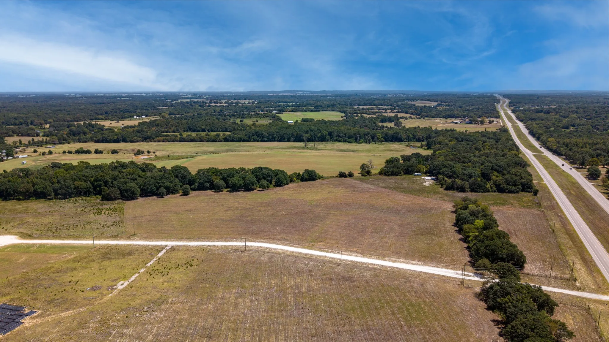 Expansive land parcel featuring a main highway and secondary road access