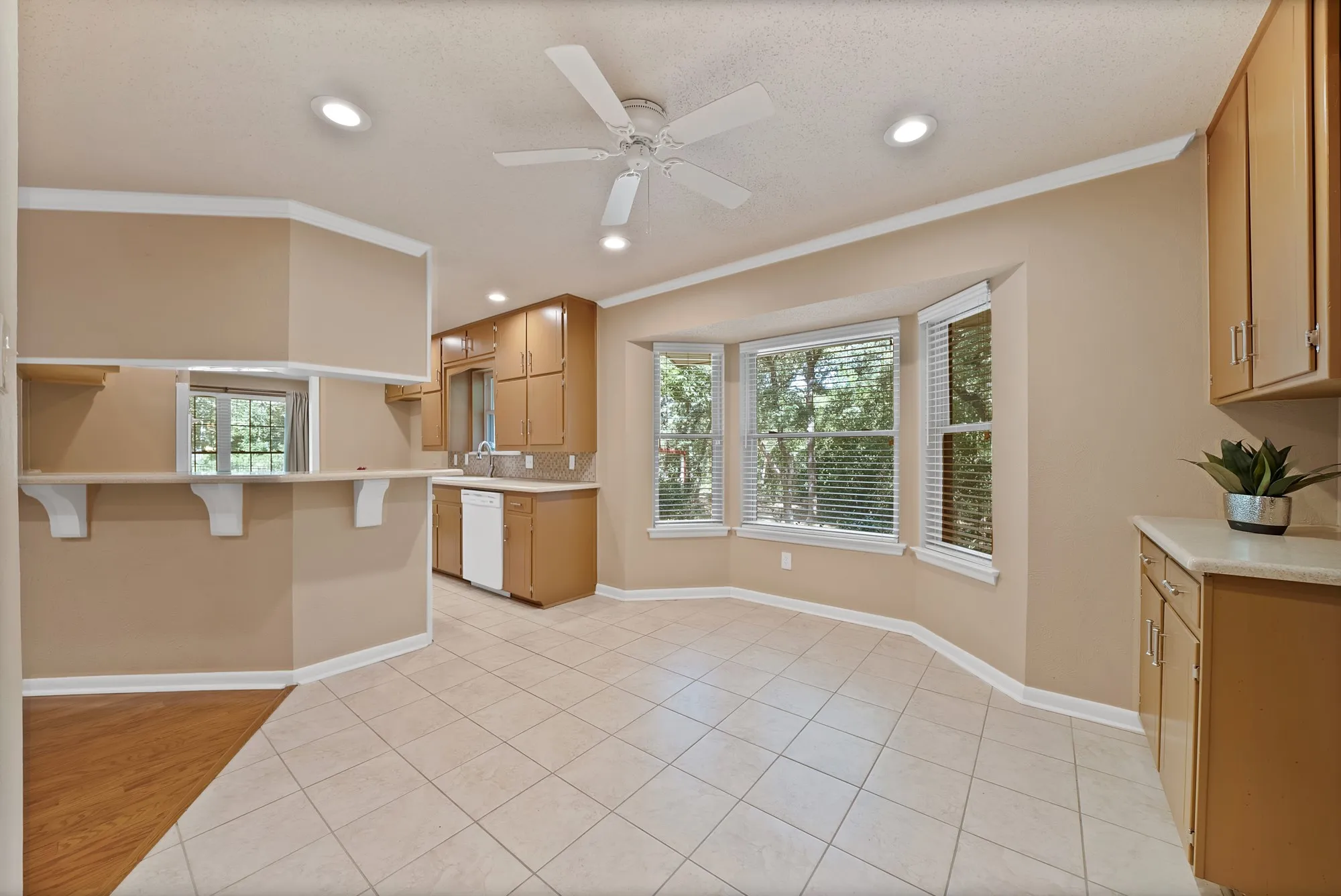Bay window with blinds, recessed lighting, ceiling fan, wood-finish flooring, and light-toned tile flooring