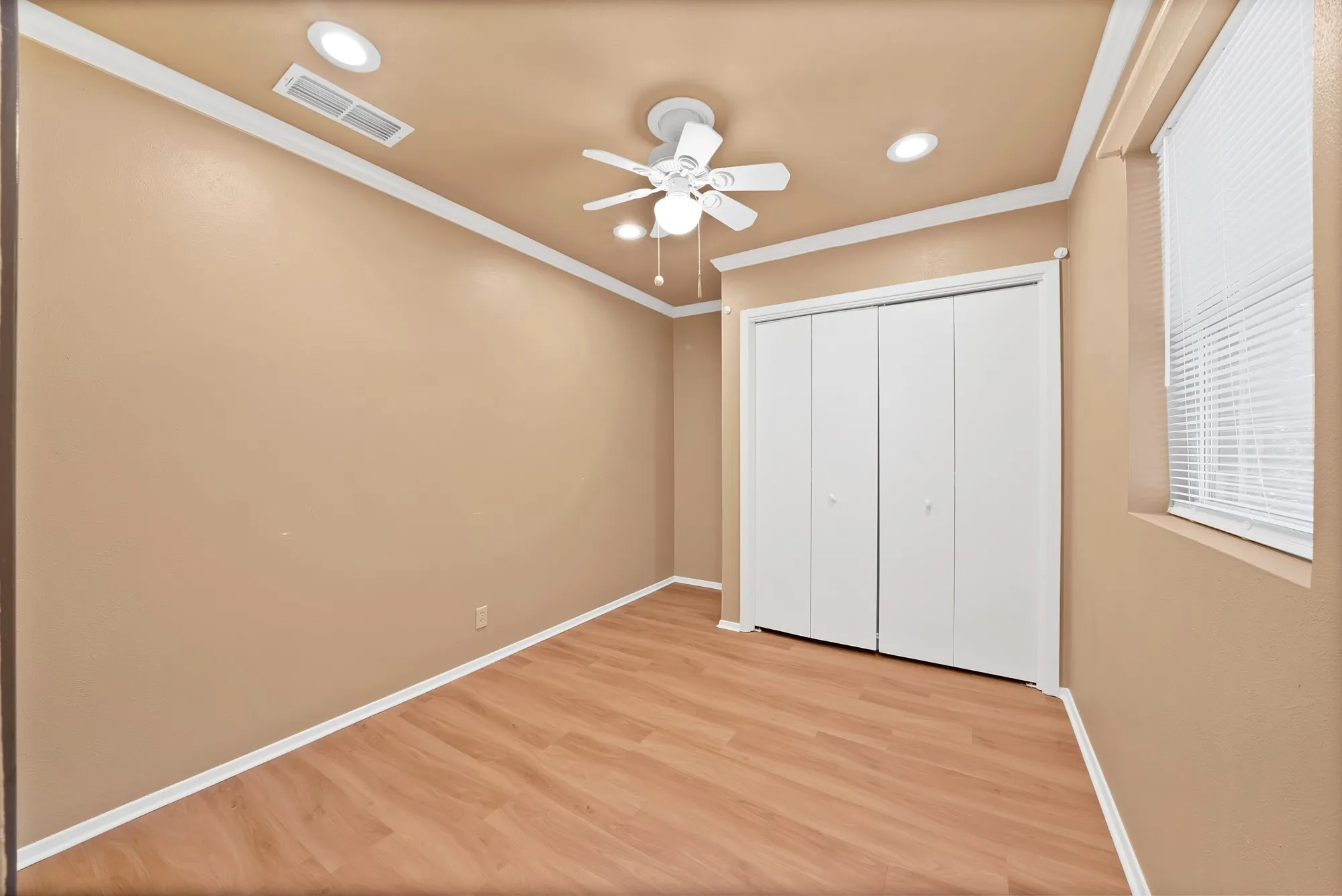 Wood-finish flooring, crown molding, ceiling fan, recessed lighting, and a window with blinds