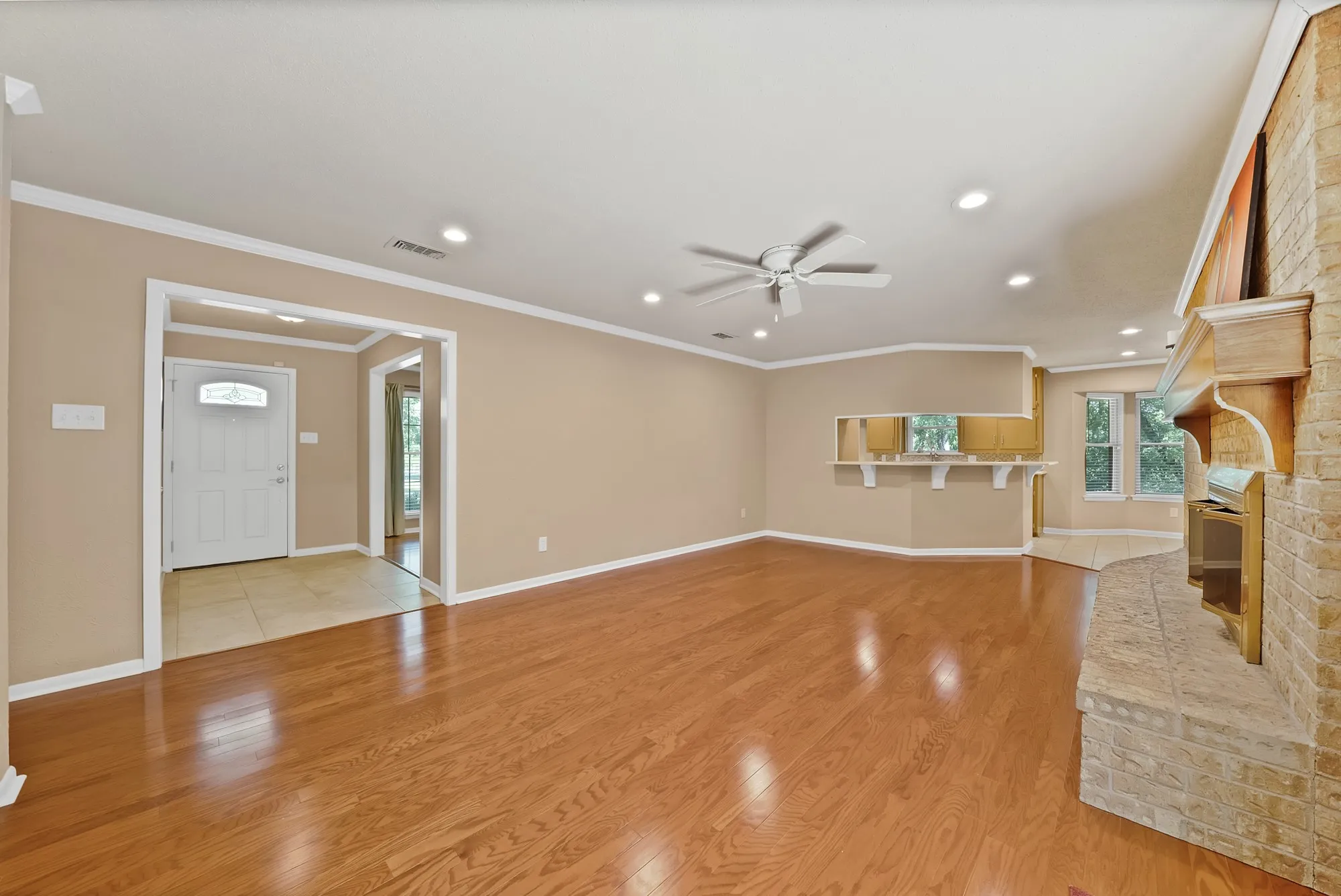 Spacious living area featuring wood-finish flooring, recessed lighting, and a ceiling fan