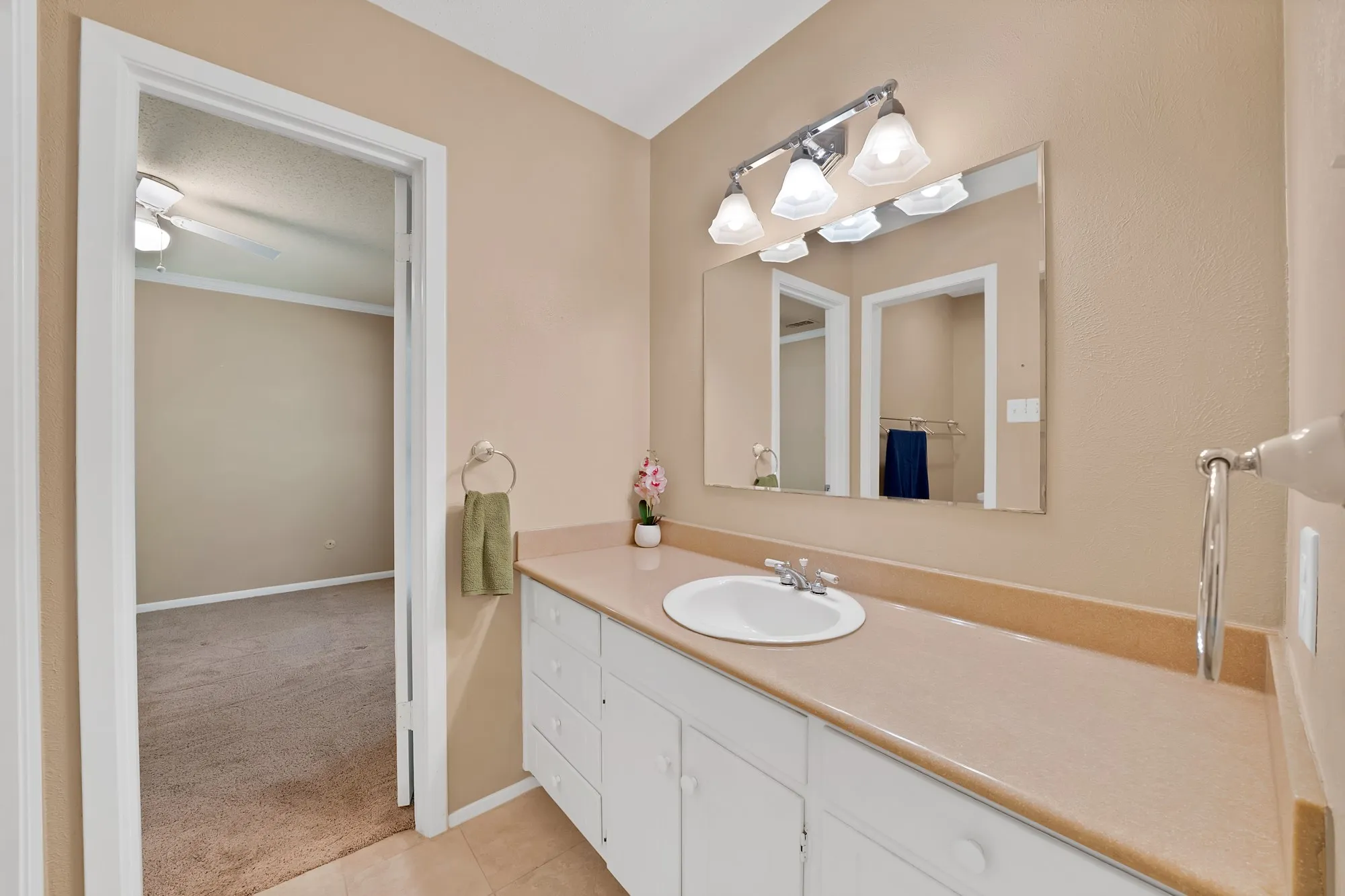 Bathroom featuring a vanity with an integrated sink, built-in cabinetry, and overhead lighting