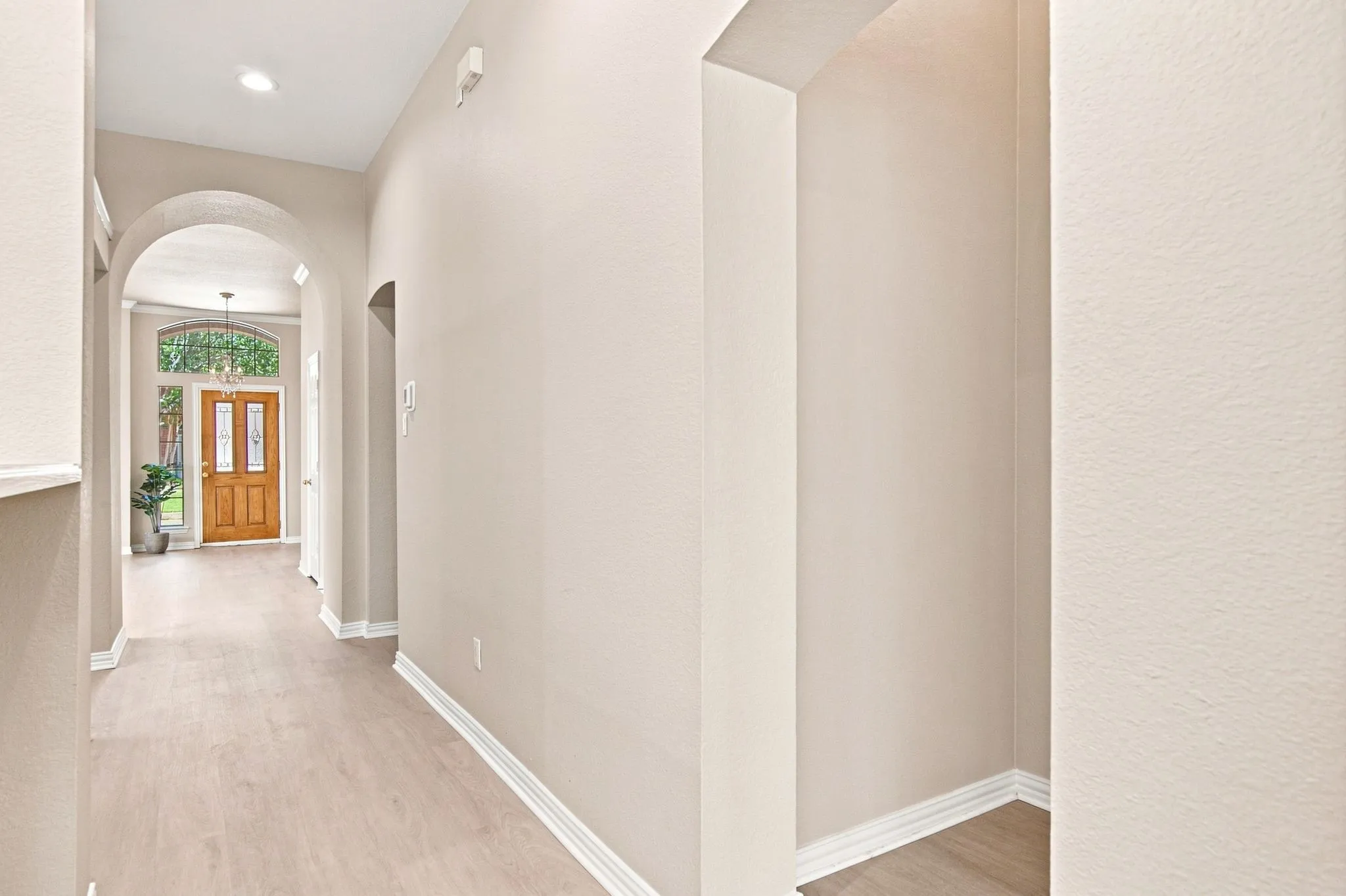 Entryway featuring wood-finish flooring, recessed lighting, and arched doorways