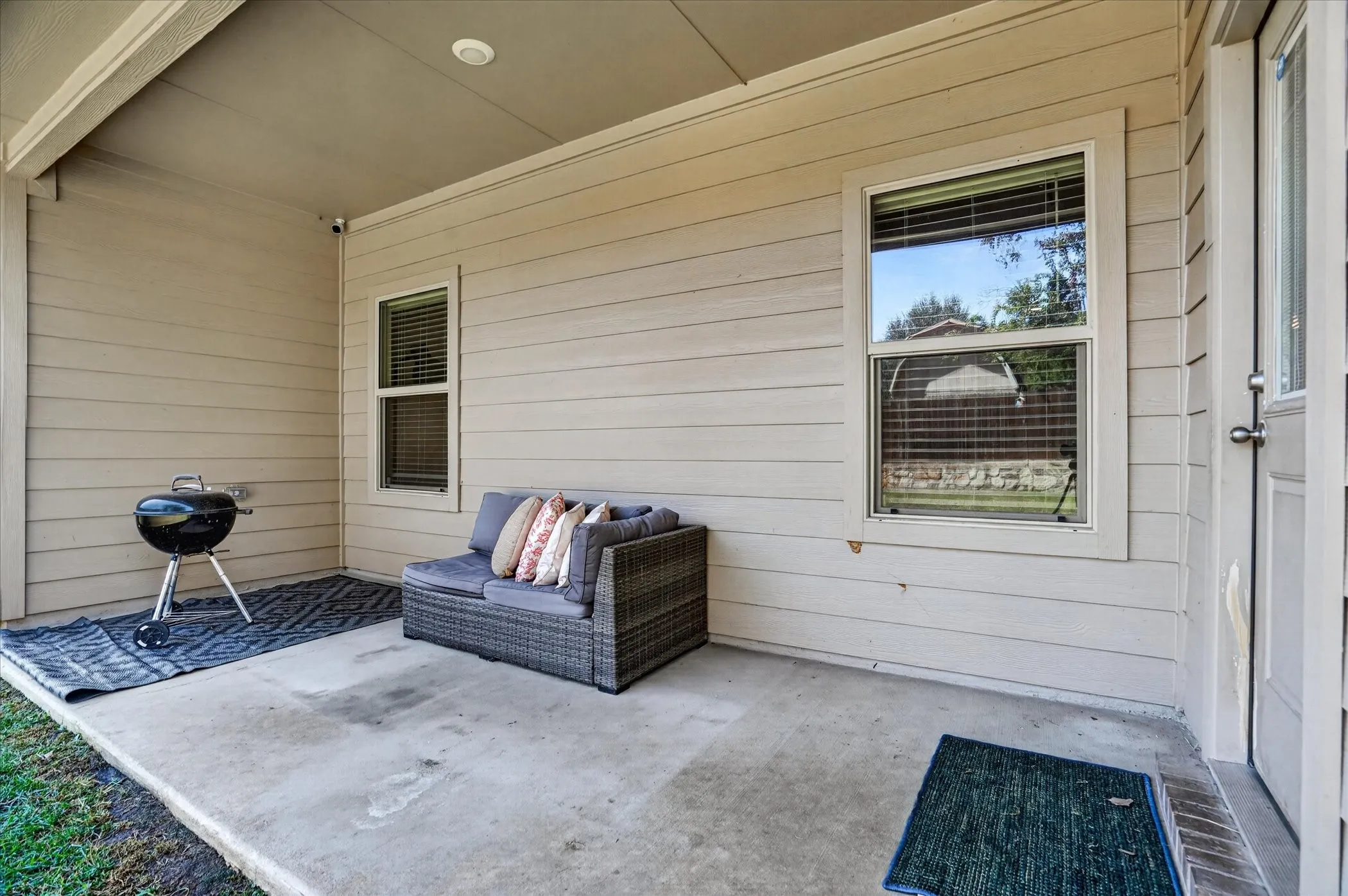 Covered concrete patio with horizontal siding and exterior door