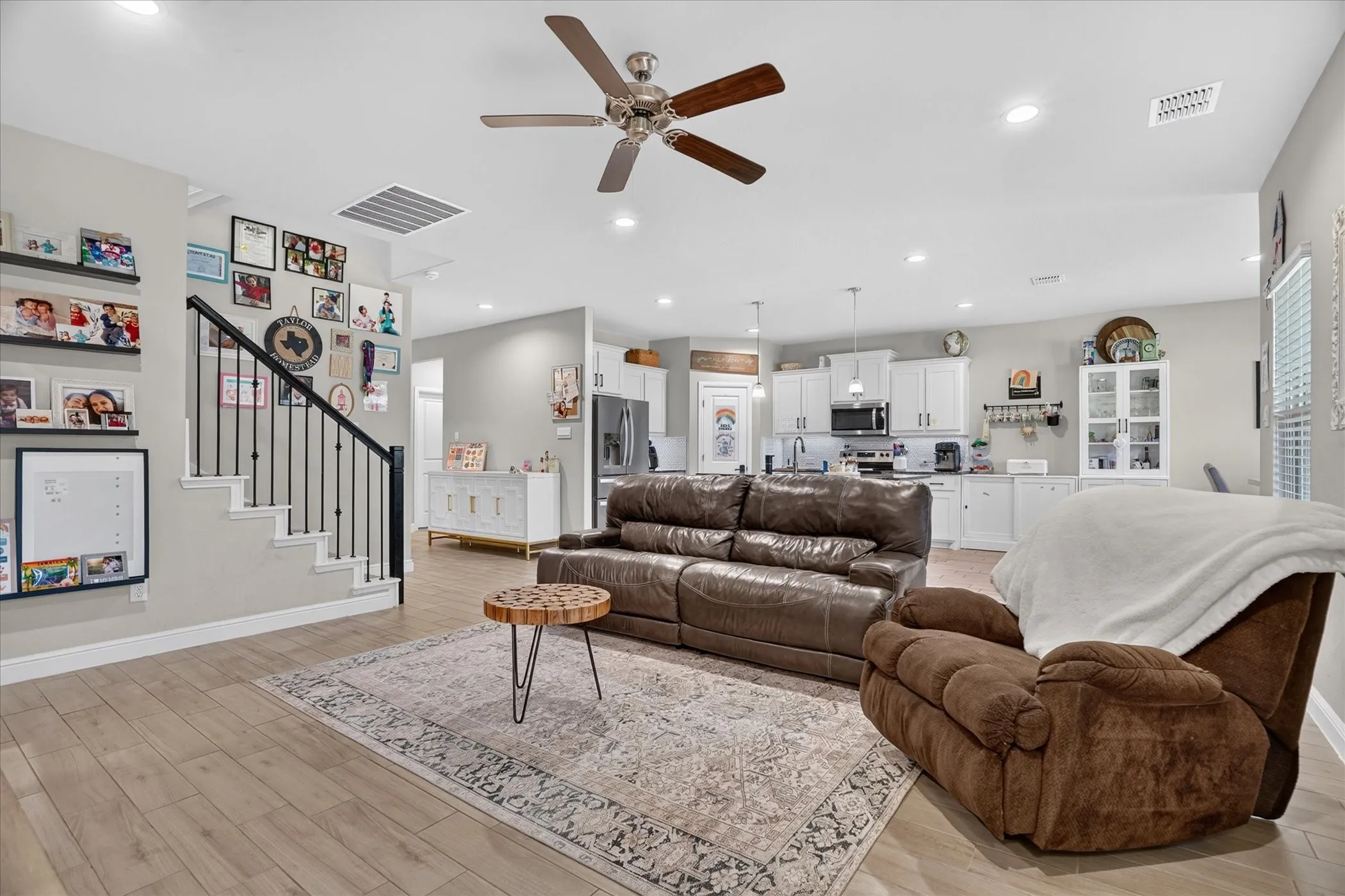 Open-concept living space featuring wood-finish flooring, a ceiling fan, and recessed lighting