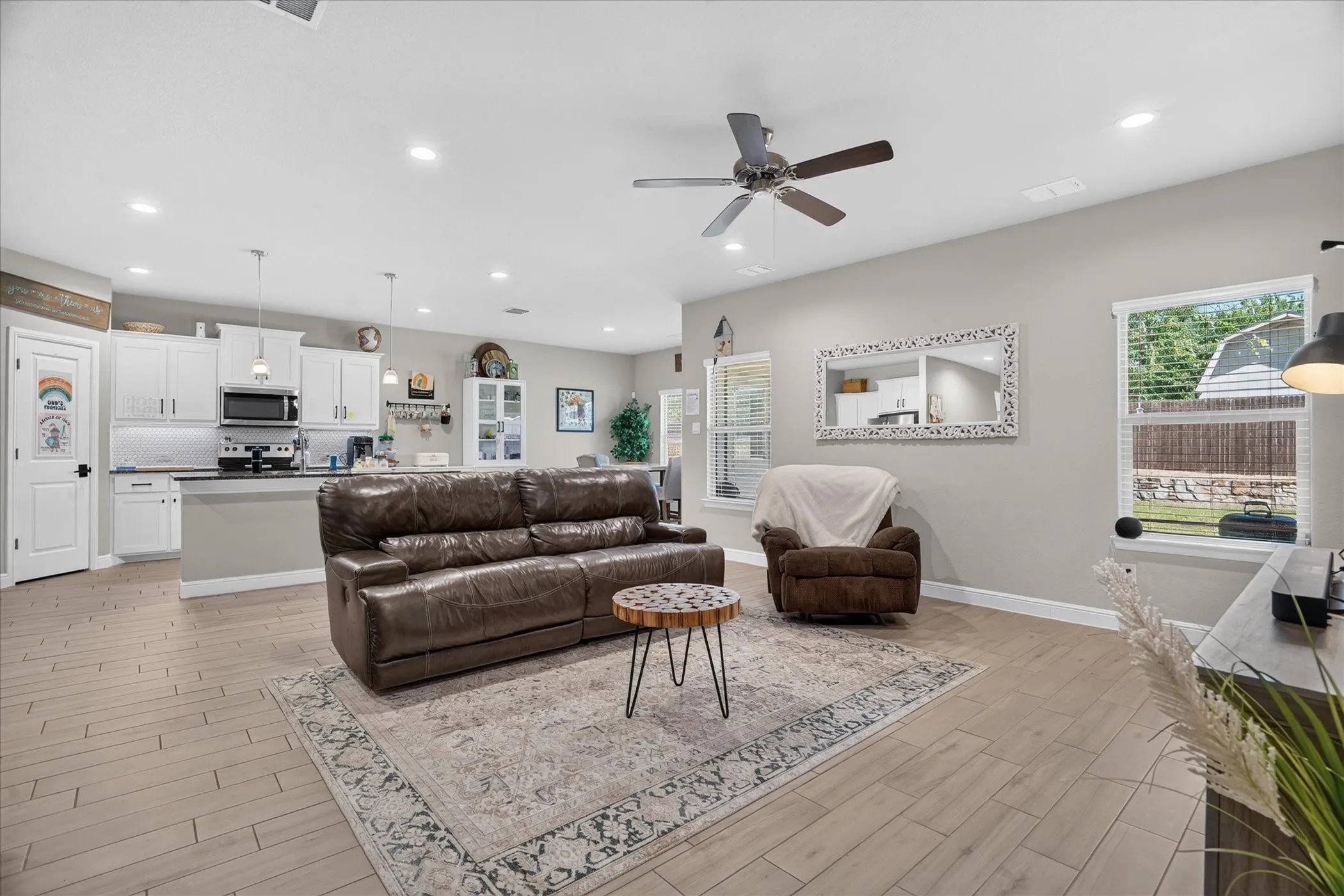 Open-concept living space with wood-finish flooring, recessed lighting, and a ceiling fan