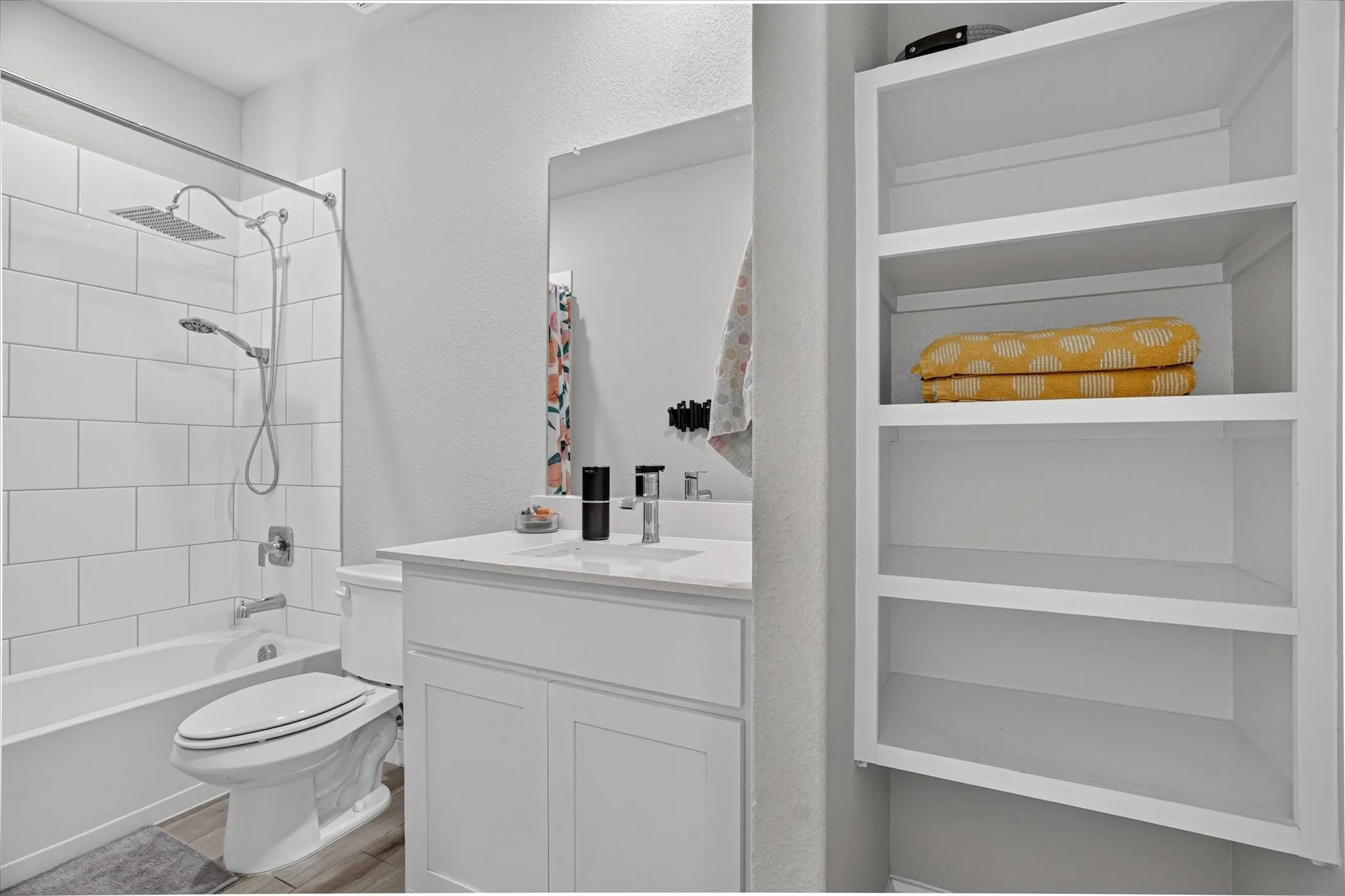 White subway tile shower surround with a rain shower head and handheld sprayer