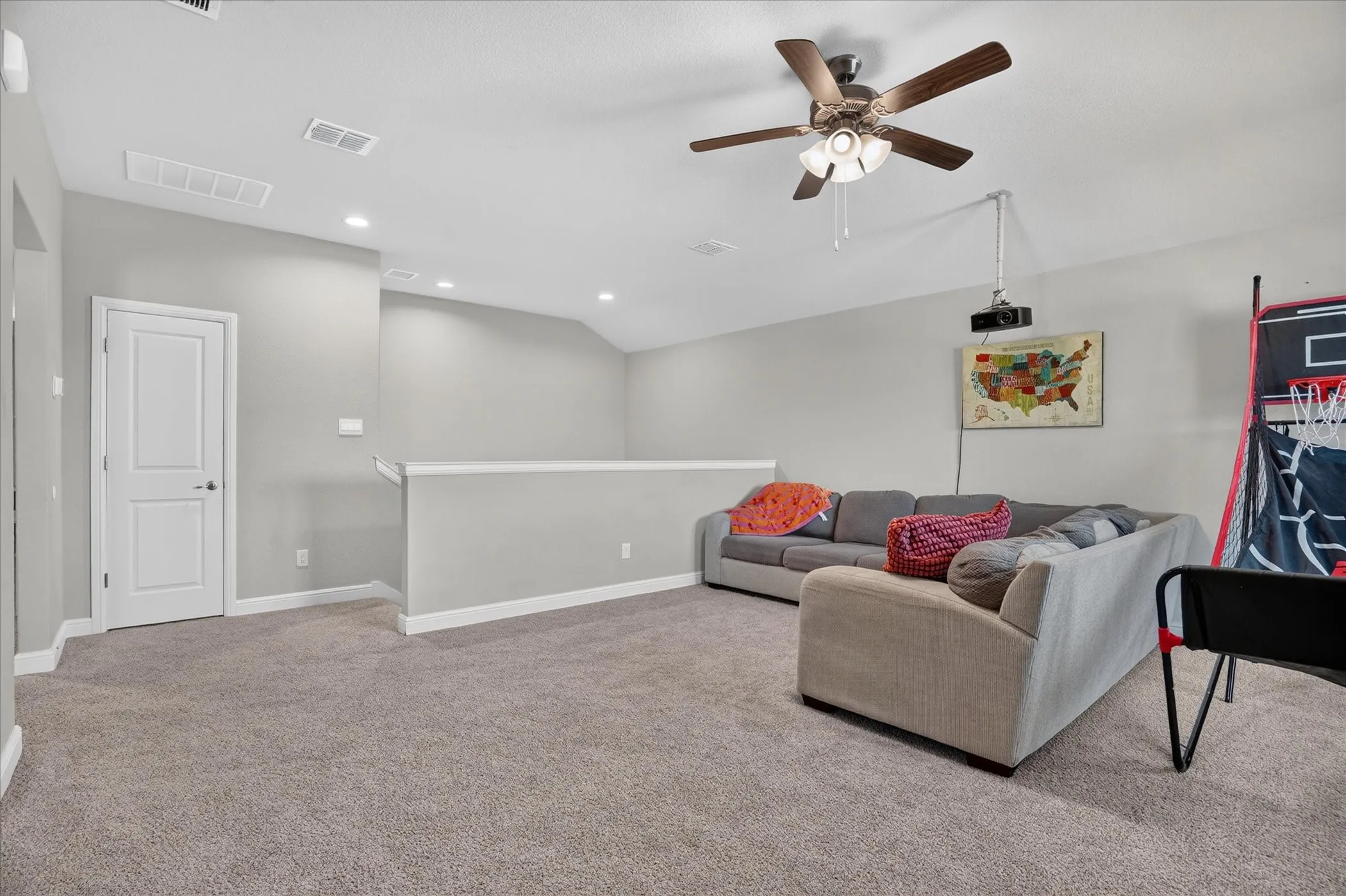 Spacious carpeted room featuring a ceiling fan with integrated lighting, recessed lighting, and a white interior door