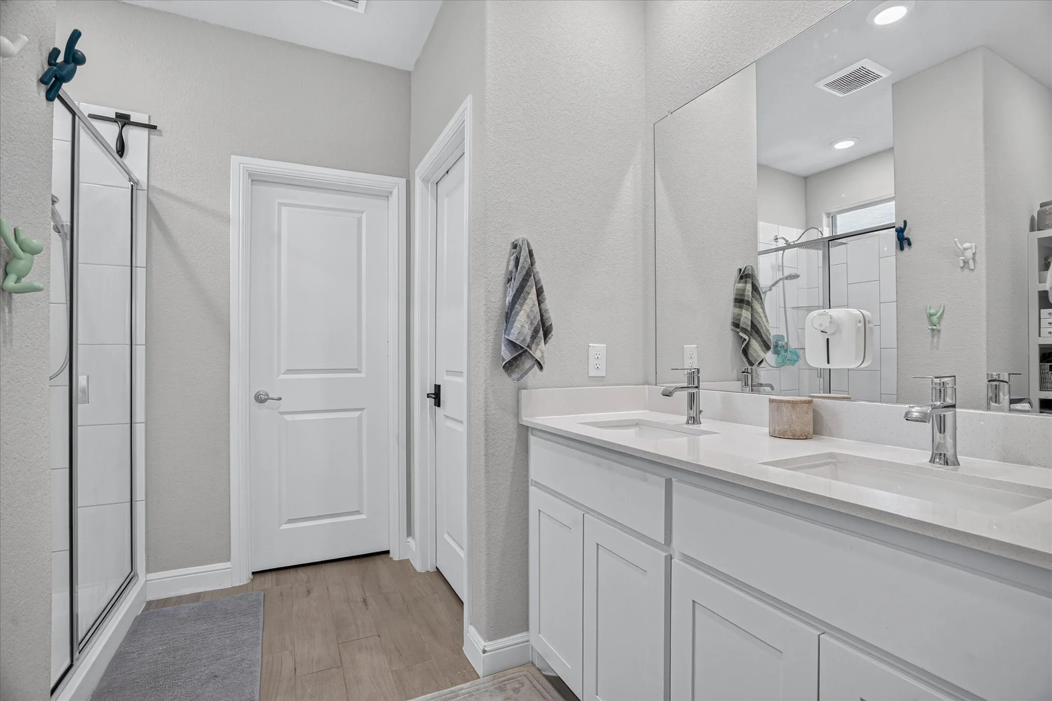 Dual vanity with undermount sinks, chrome fixtures, and white cabinetry
