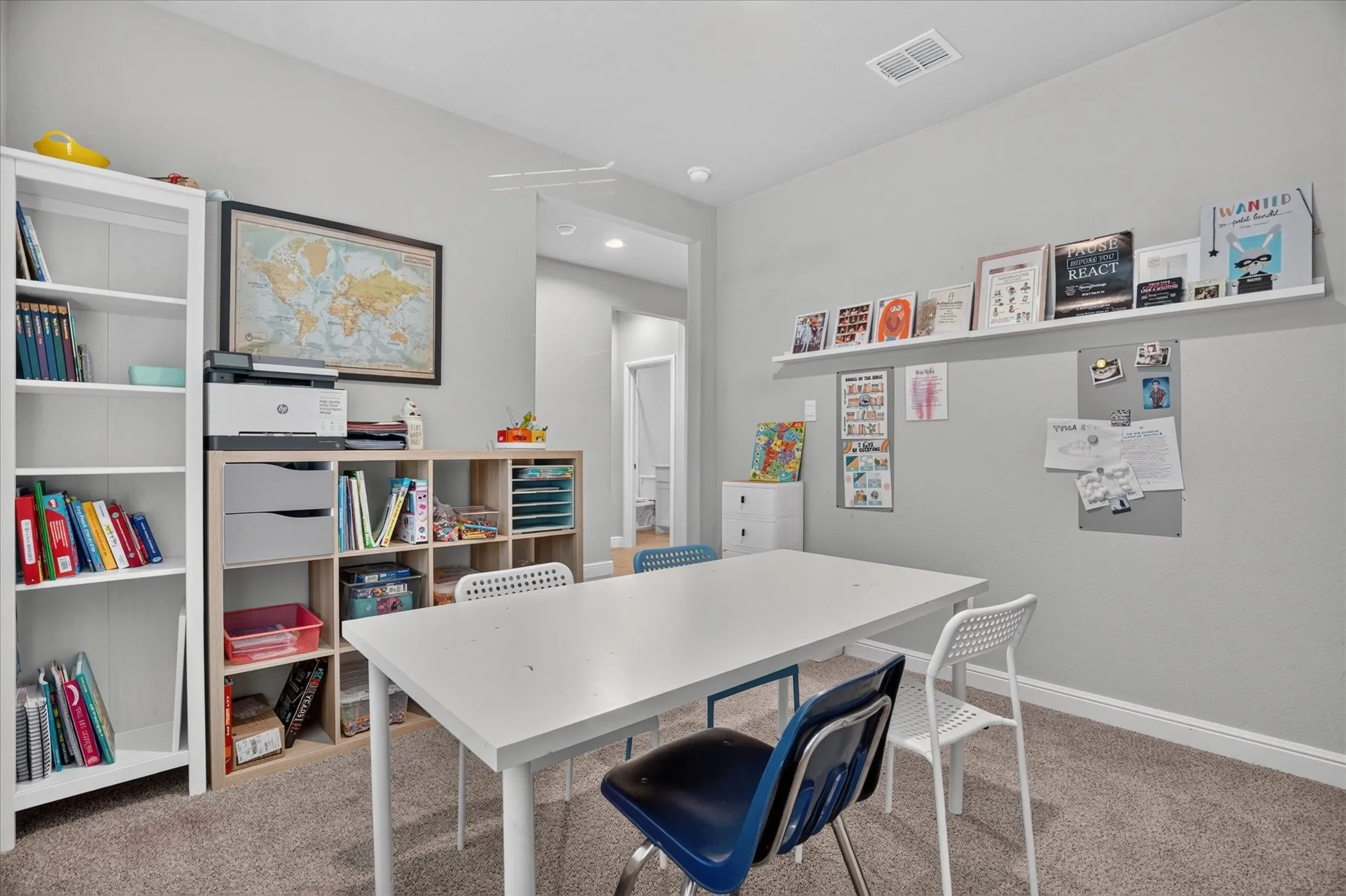 Light gray wall paint, recessed lighting, wall-mounted display shelving, and light brown carpet flooring