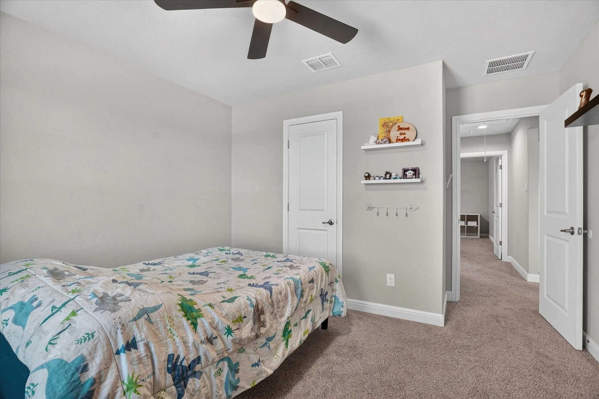 Neutral wall paint, ceiling fan with light, and carpeted flooring