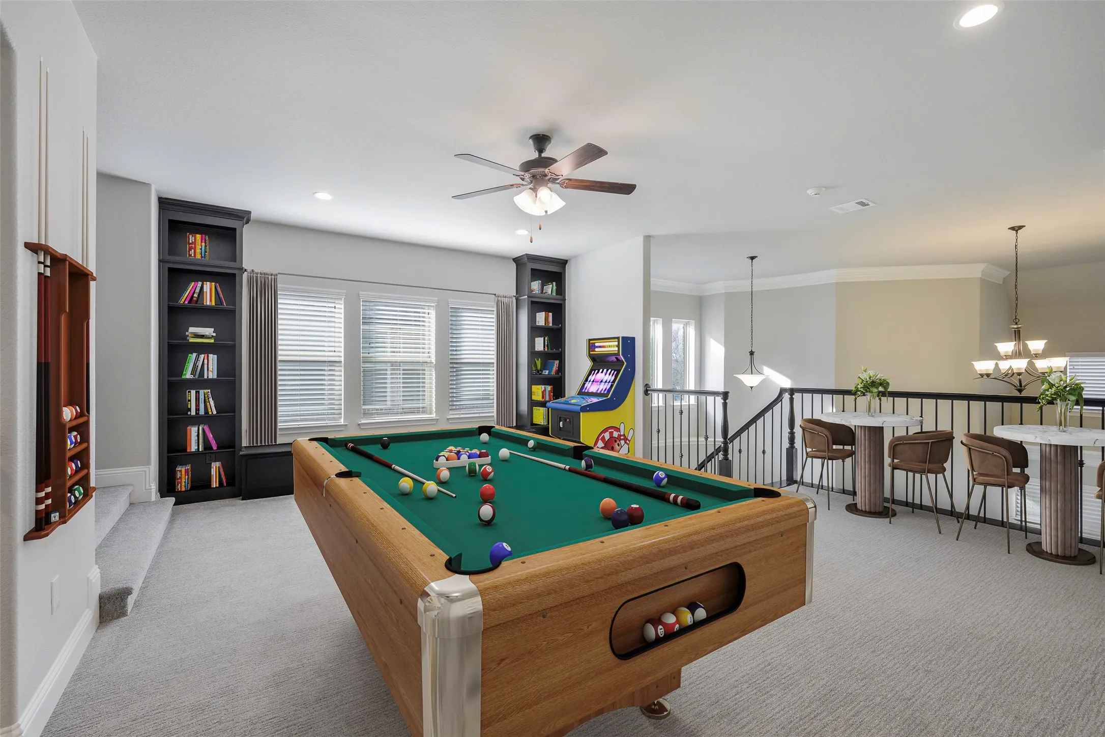 Loft area featuring built-in shelving, ceiling fan, and carpeted flooring